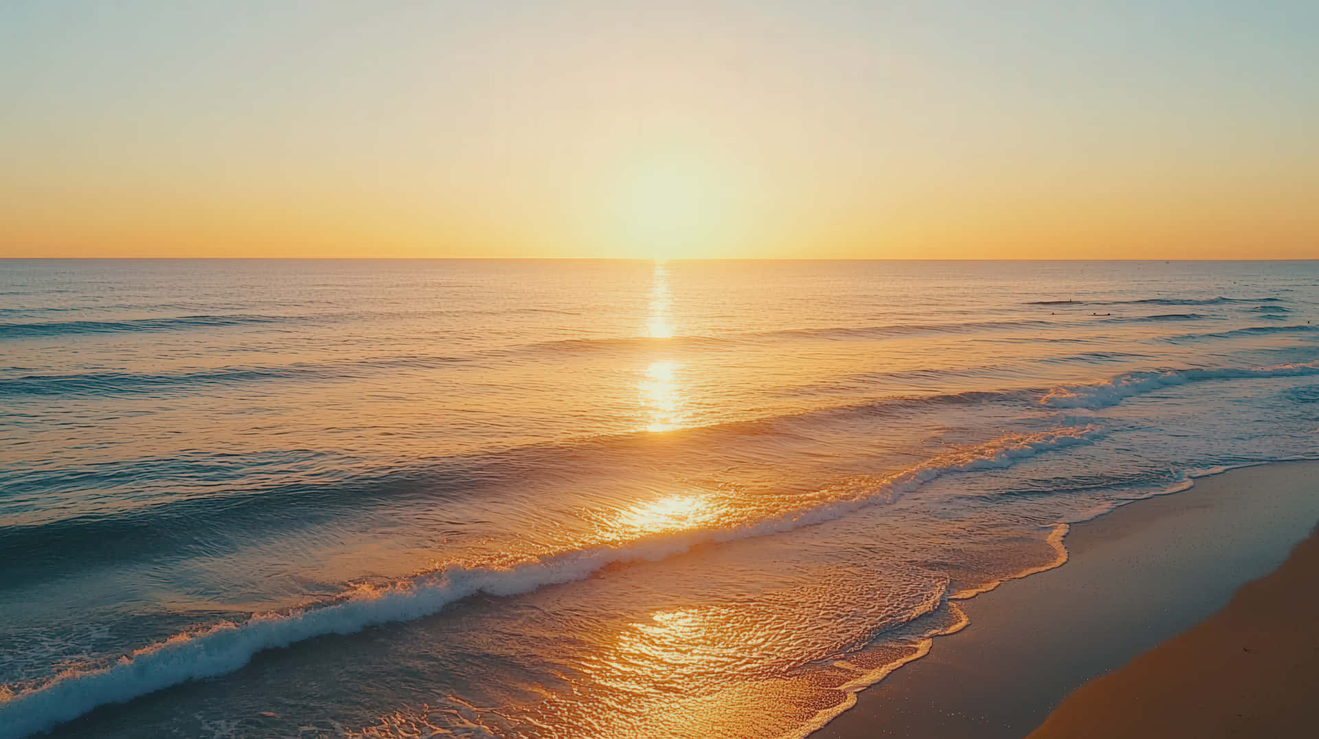 Breathtaking Ocean Sunset with Golden Reflections on Gentle Waves and a Serene Beach Horizon 壁紙 — 金色日出在黎明時分閃爍在平靜的海浪上，海浪滾滾而來，拍打著沙灘。