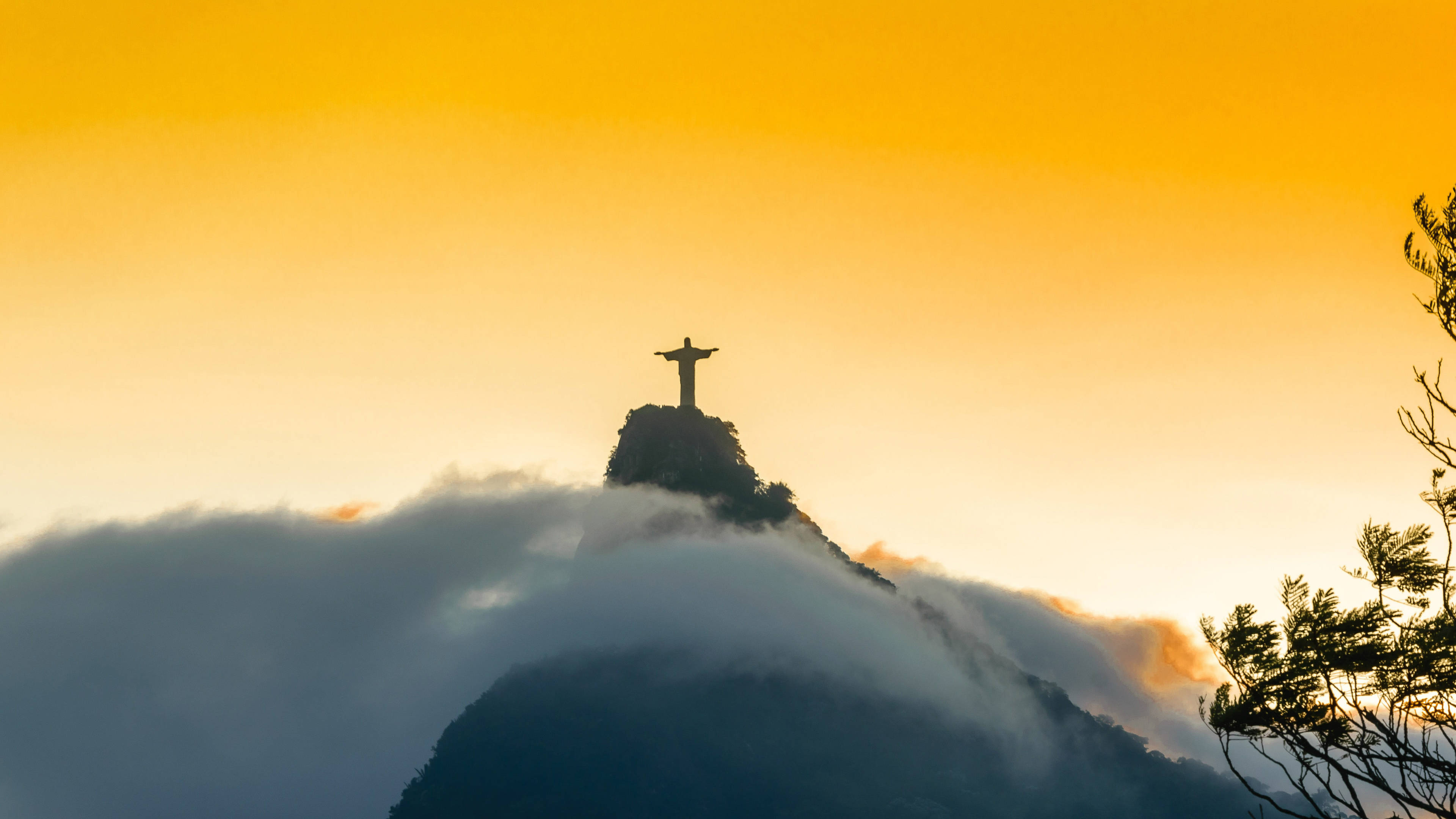 rio 桌布 壁紙 — 金色日出時，科爾科瓦多山頂的基督像剪影從雲層中浮現。
