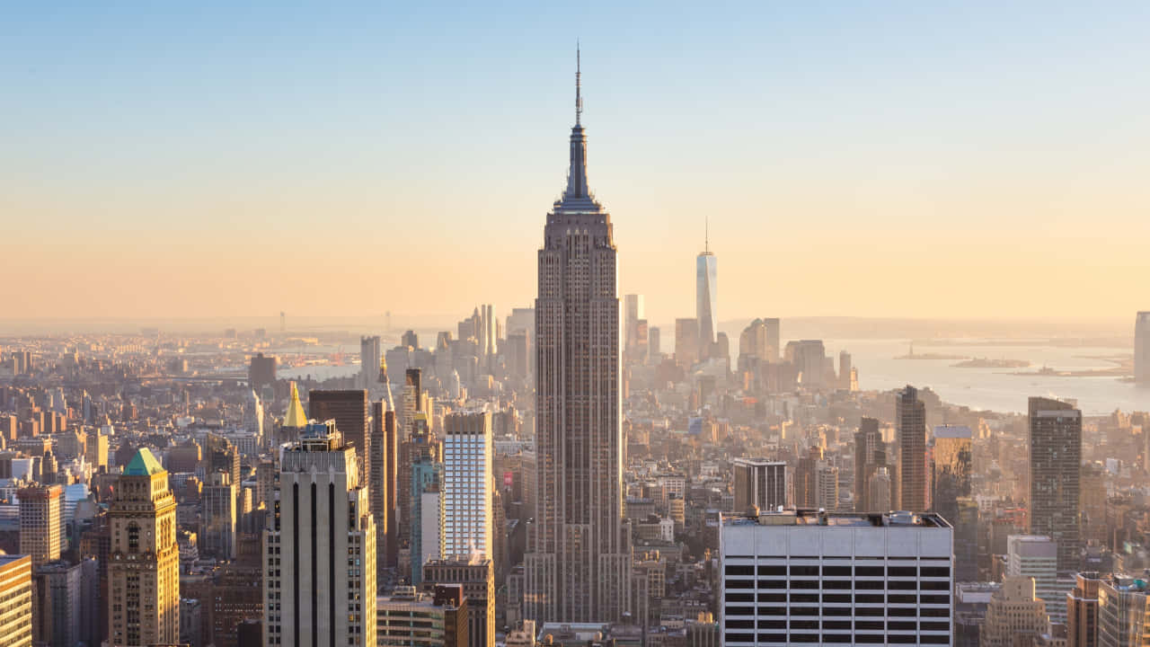 720p Ny City 桌布 壁紙 — 金色日出沐浴著標誌性的帝國大廈和紐約市天際線，溫暖的光芒。