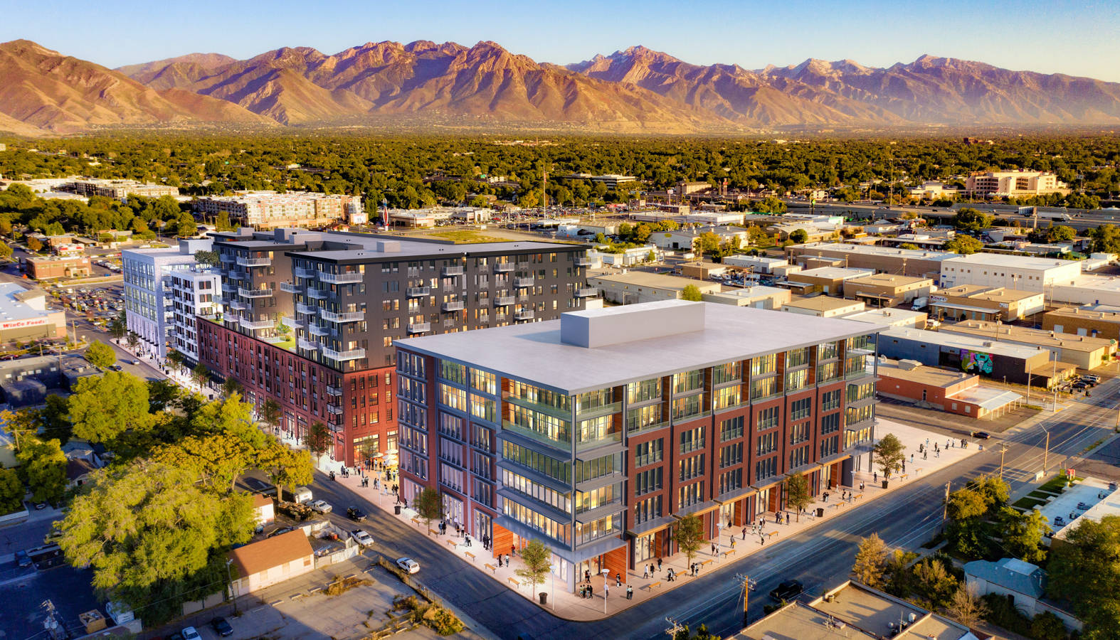 Salt Lake City 桌布 壁紙 — 金色日落光線下，以遠山為背景的現代城市建築（紅磚和玻璃外牆）的鳥瞰圖。