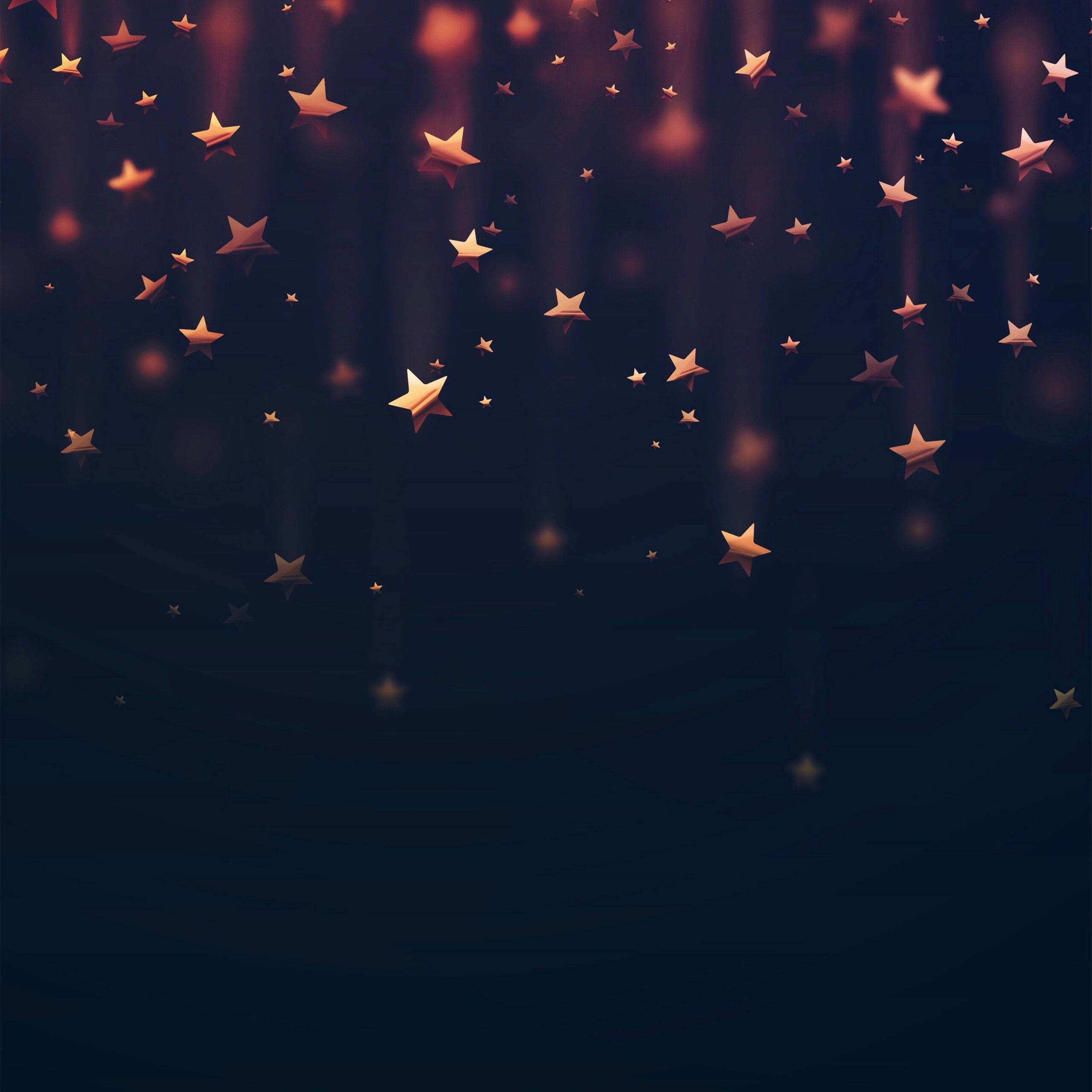 Stars 桌布 壁紙 — 金色星星在溫暖光線的柔和垂直光束照射下，穿過深藍色虛空向下飄落。