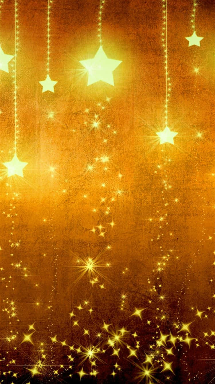 Gold Stars 桌布 壁紙 — 金色星星從發光的繩子上垂下來，背景是充滿閃爍光線的紋理琥珀色背景。