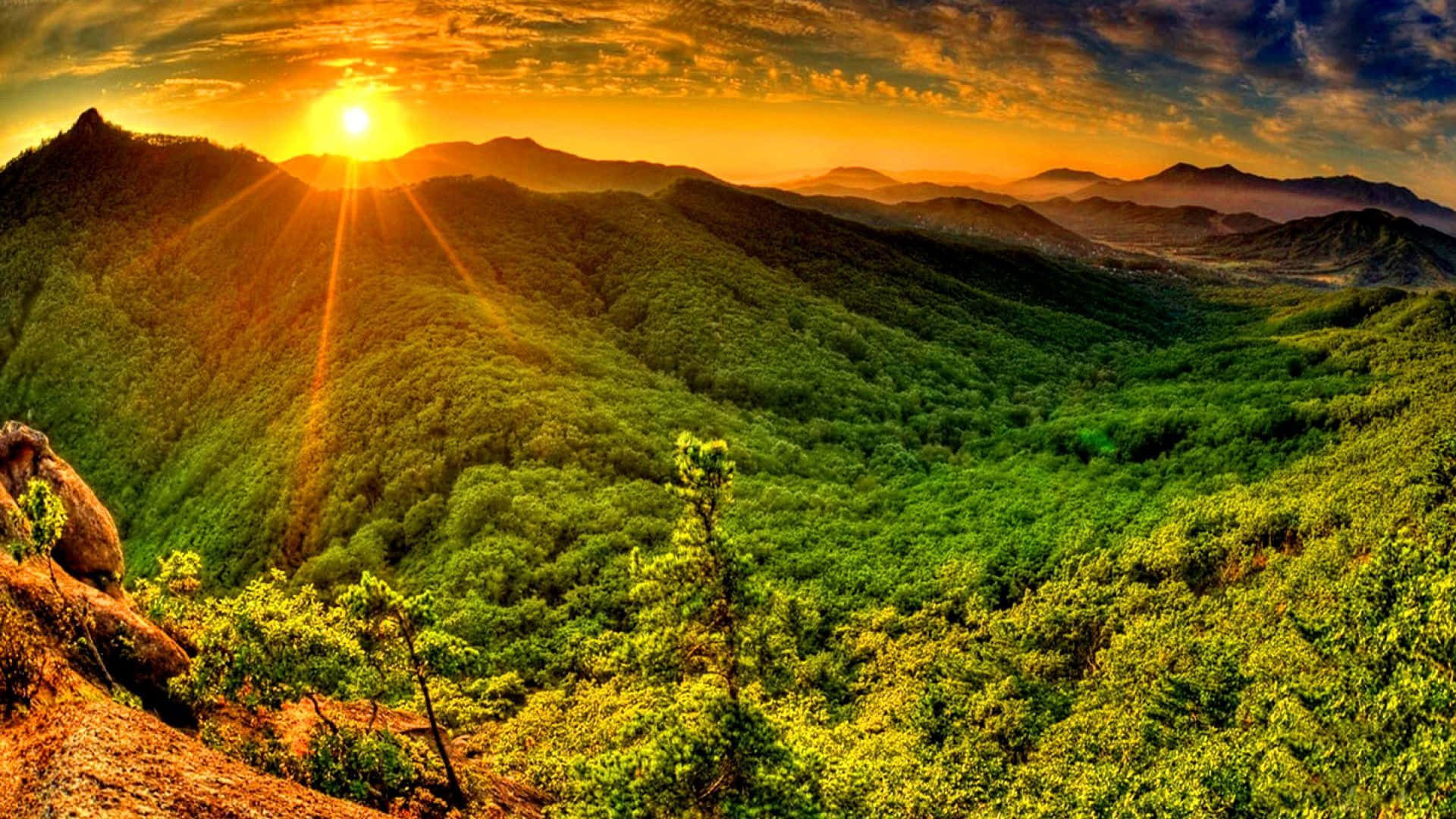 山景 桌布 壁紙 — 金色時分，陽光穿透雲層，照耀在鬱鬱蔥蔥的綠色山谷上。