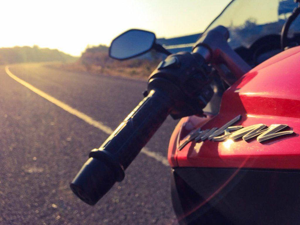 Racing 桌布 壁紙 — 金色時分陽光普照的沙漠公路上，紅色摩托車的把手和油箱特寫。