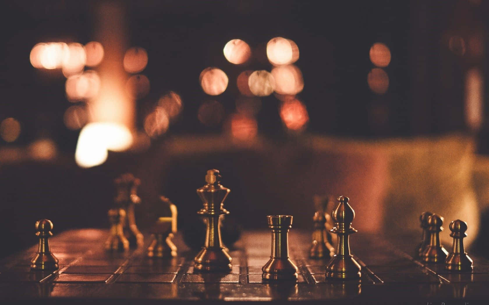 西洋棋 桌布 壁紙 — 金色棋子在昏暗的房間中，於溫暖的散景燈光下，佇立在深色棋盤上。