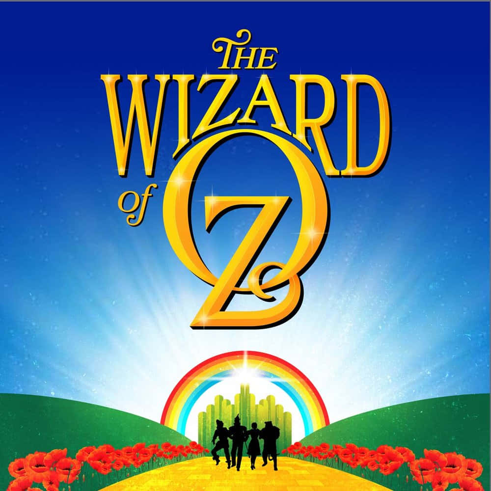 wizard of oz 桌布 壁紙 — 金色標題《綠野仙蹤》照耀在拱形彩虹之上，彩虹橫跨一條黃磚路，路上有剪影人物走向城市。