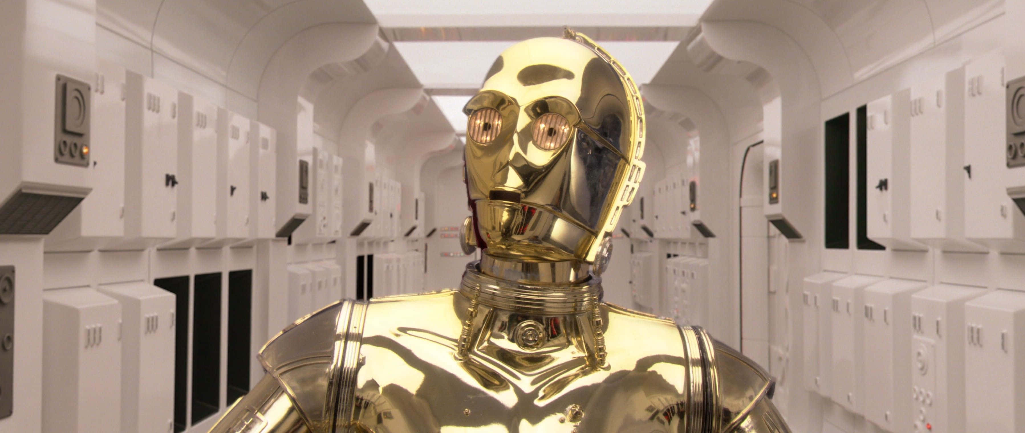 C-3po 桌布 壁紙 — 金色機器人 C-3PO 站在一個無菌的白色走廊，兩旁是伺服器機架，上方有明亮的燈光。