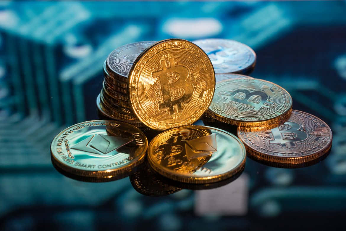 Money 桌布 壁紙 — 金色比特幣和以太幣硬幣放置在反光表面上，背景是模糊的藍色電路板。