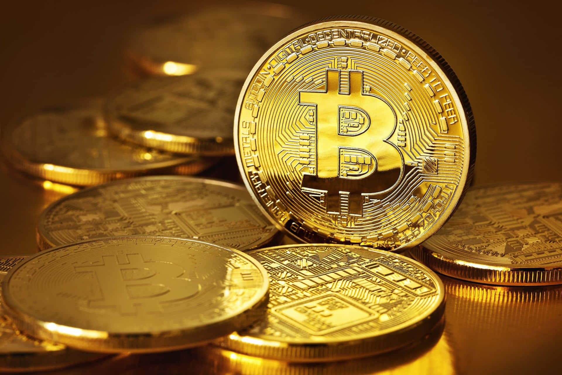 比特幣 桌布 壁紙 — 金色比特幣在溫暖燈光下閃爍，表面刻有複雜的電路圖案。