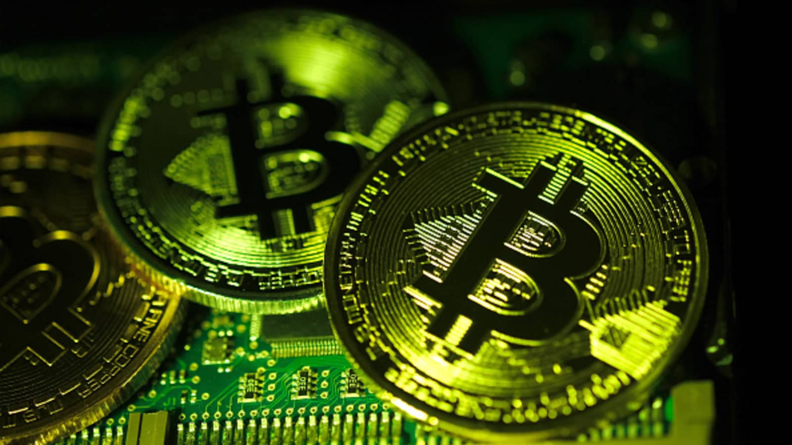 Cryptocurrency 桌布 壁紙 — 金色比特幣在詳細的電路板上發出霓虹綠光。