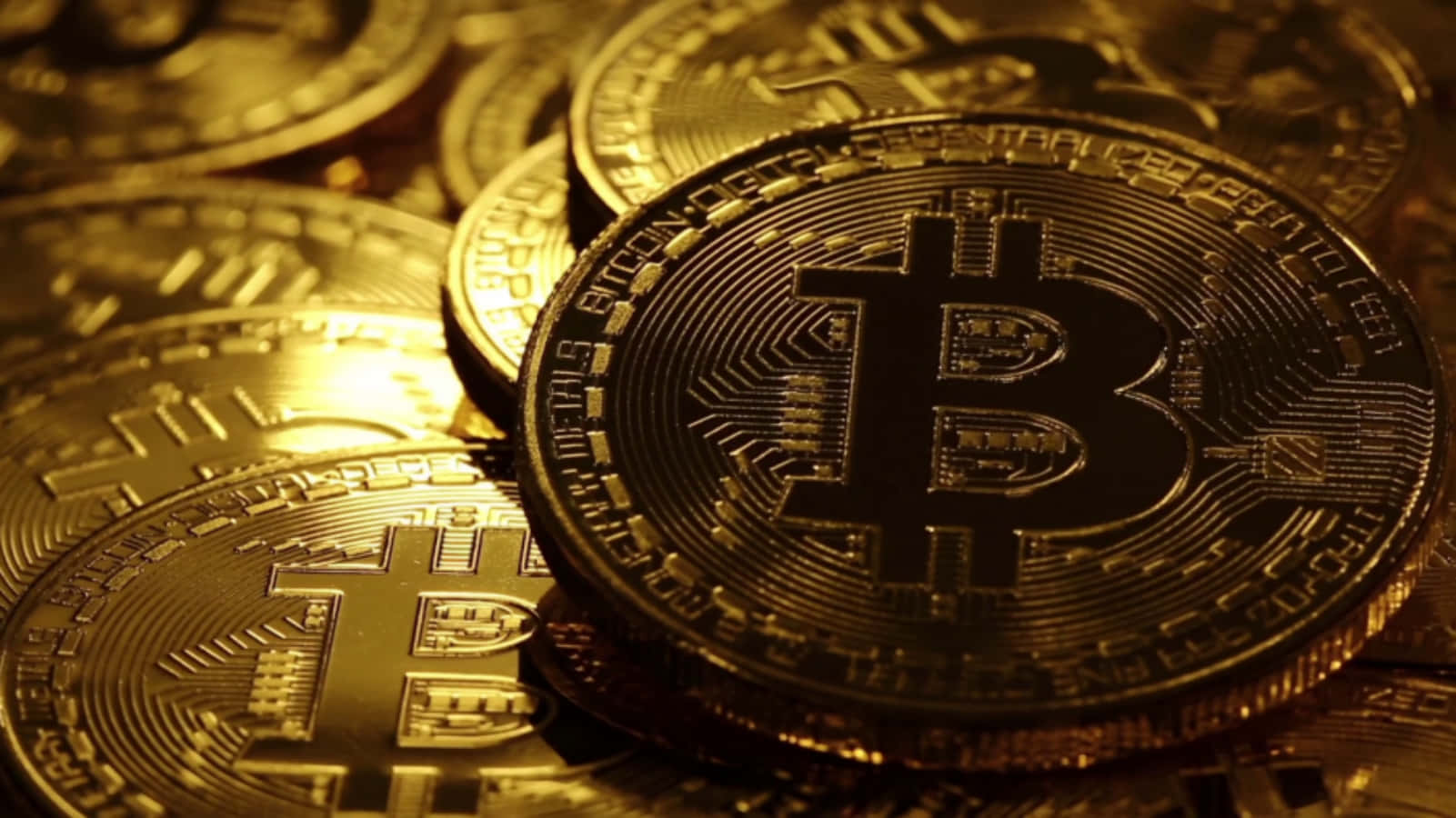 比特幣 桌布 壁紙 — 金色比特幣硬幣在溫暖光線中堆疊，複雜的電路設計在聚焦照明下發光。
