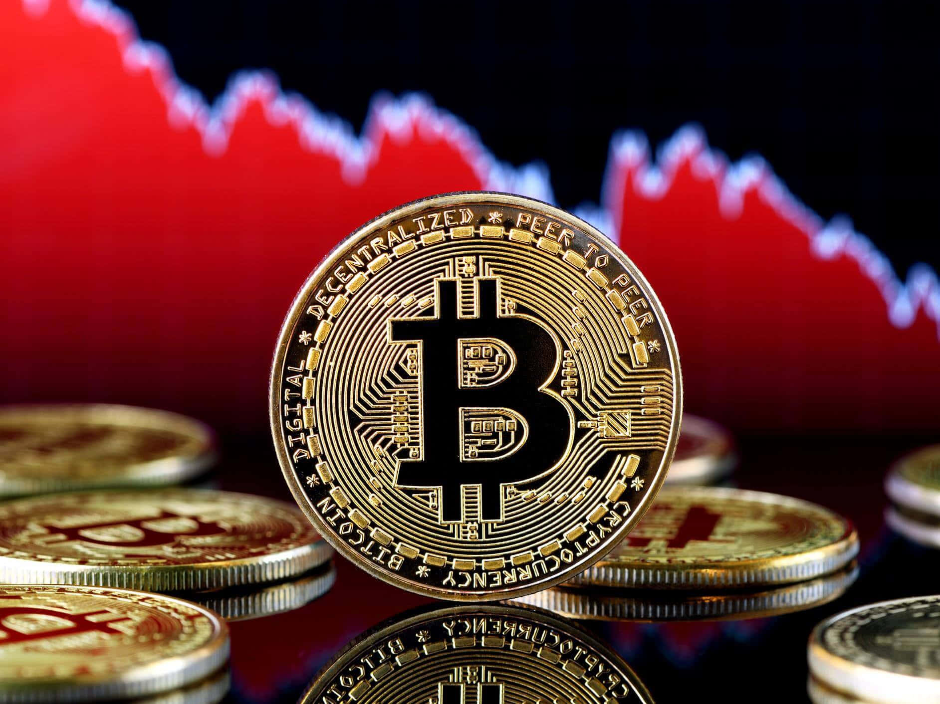 比特幣 桌布 壁紙 — 金色比特幣硬幣排列在反光表面上，背景有紅色下跌的股票圖表。
