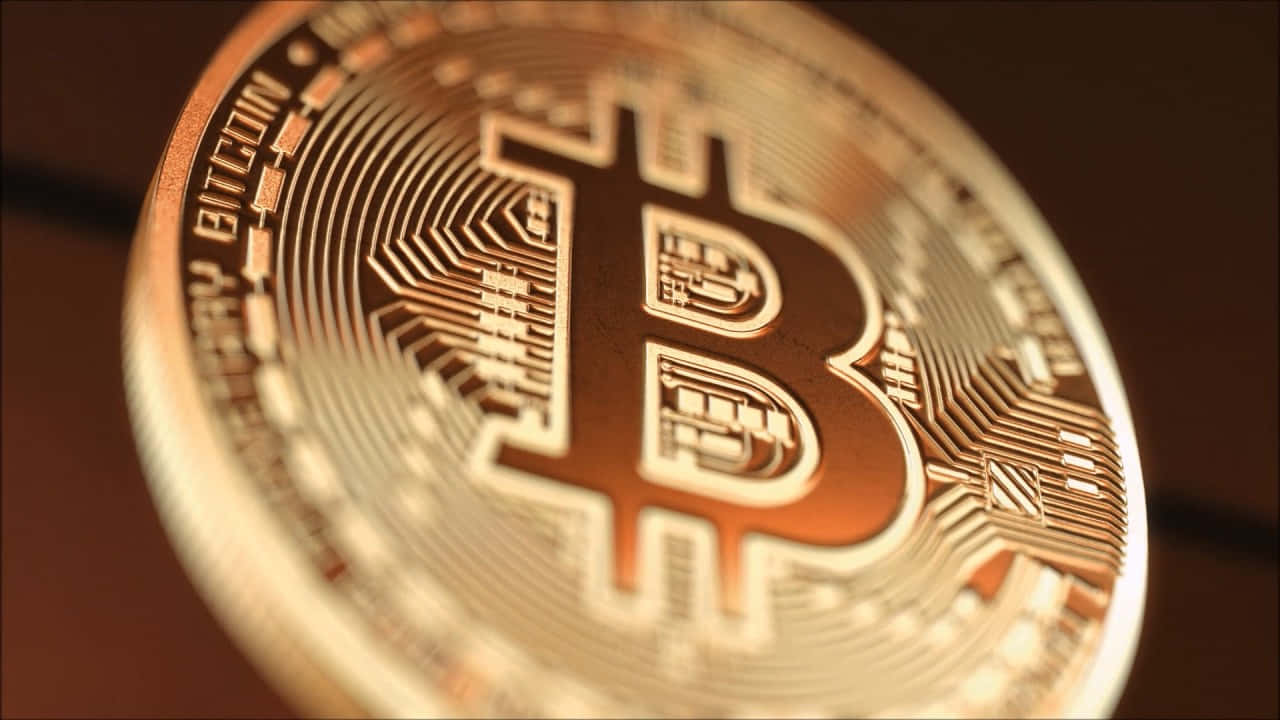 比特幣 桌布 壁紙 — 金色比特幣硬幣的特寫，帶有電路板圖案，在溫暖的光線下發光。