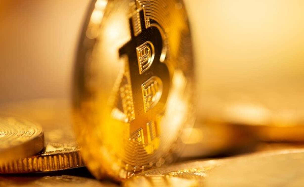 Money 桌布 壁紙 — 金色比特幣硬幣的特寫，背景模糊，有類似硬幣在溫暖燈光下。