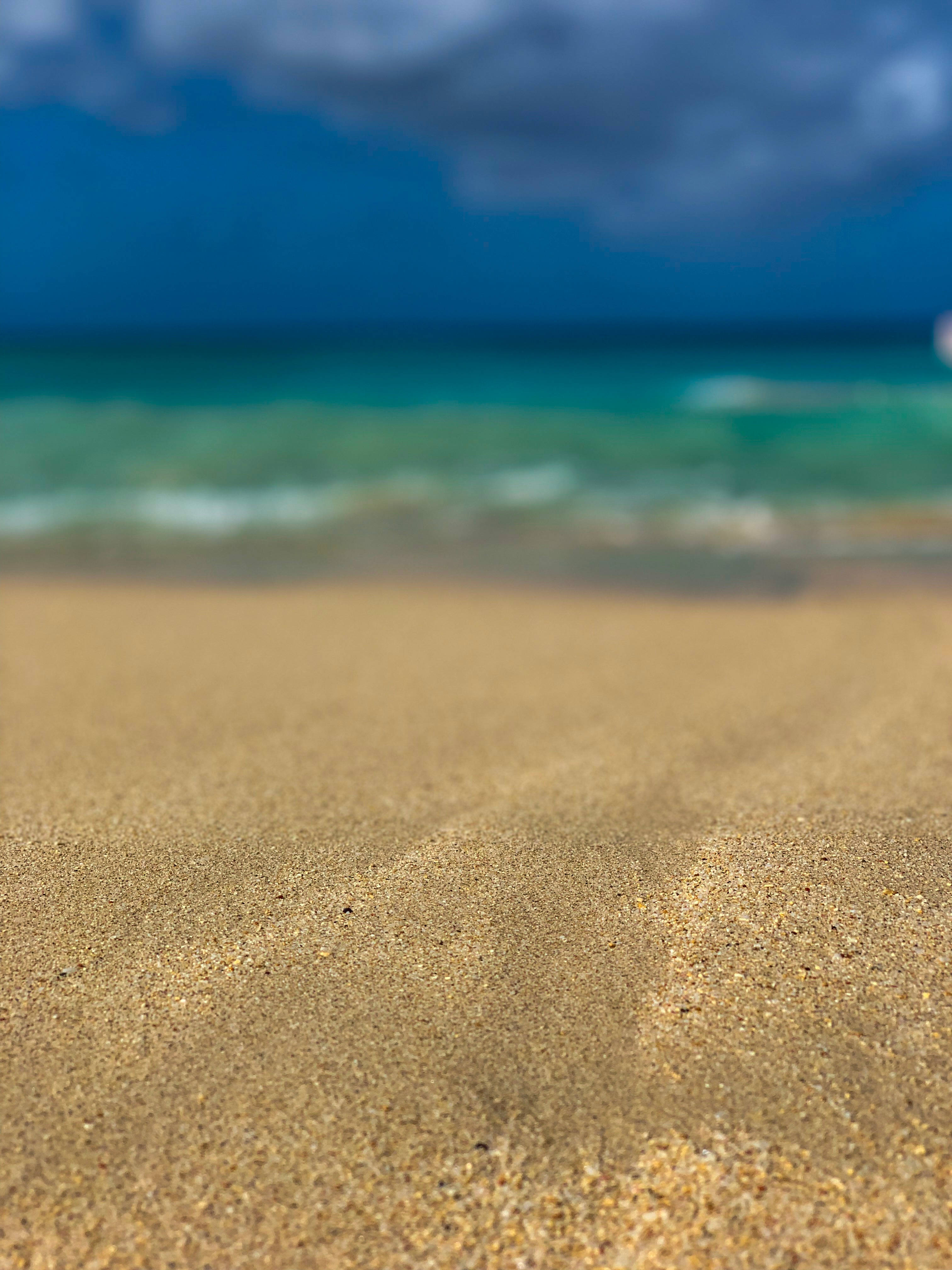 Barbados 桌布 壁紙 — 金色沙灘與碧綠海浪在戲劇性的多雲天空下相遇的特寫。