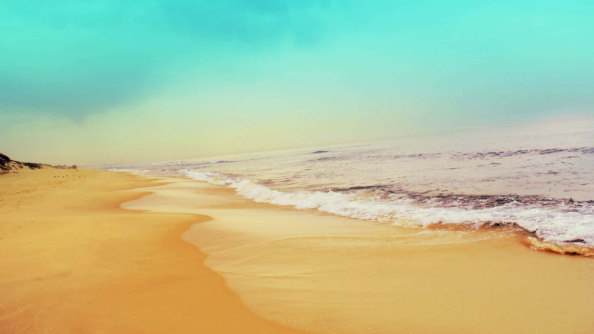 HD Beach 桌布 壁紙 — 金色沙灘輕輕彎曲，碧綠海浪在柔和朦朧的天空下翻滾而來。