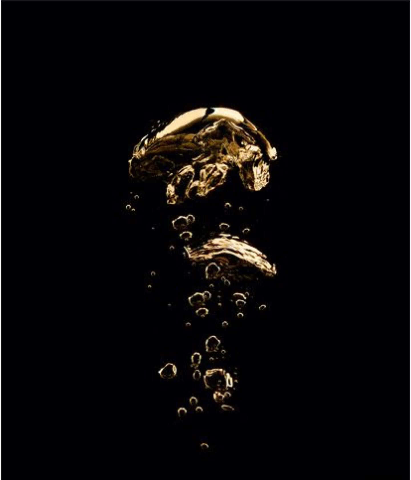 Black And Gold Aesthetic 桌布 壁紙 — 金色液體飛濺在黑色背景上半空凝固，帶有尾隨氣泡。
