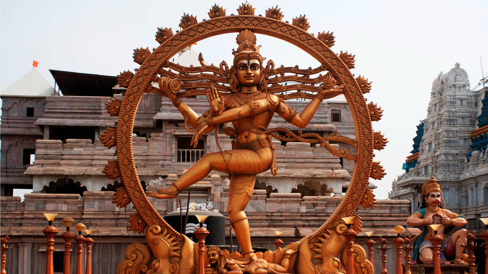 Hindu Temple 桌布 壁紙 — 金色濕婆神像在宇宙圈中跳舞，位於雕刻精細、石造建築的寺廟頂部。