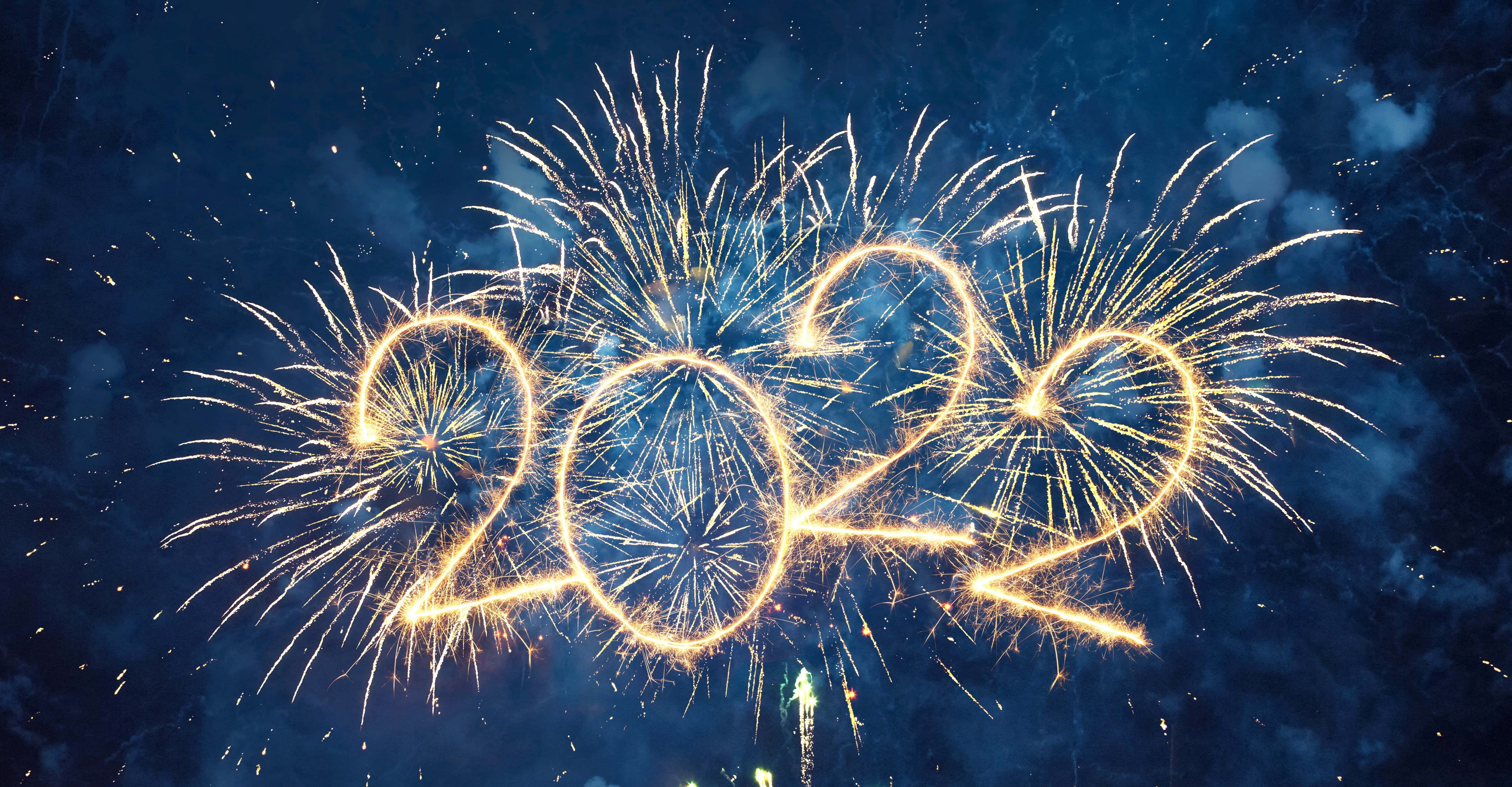 新年 桌布 壁紙 — 金色煙火在深藍色夜空和散落的煙霧中拼出2022。