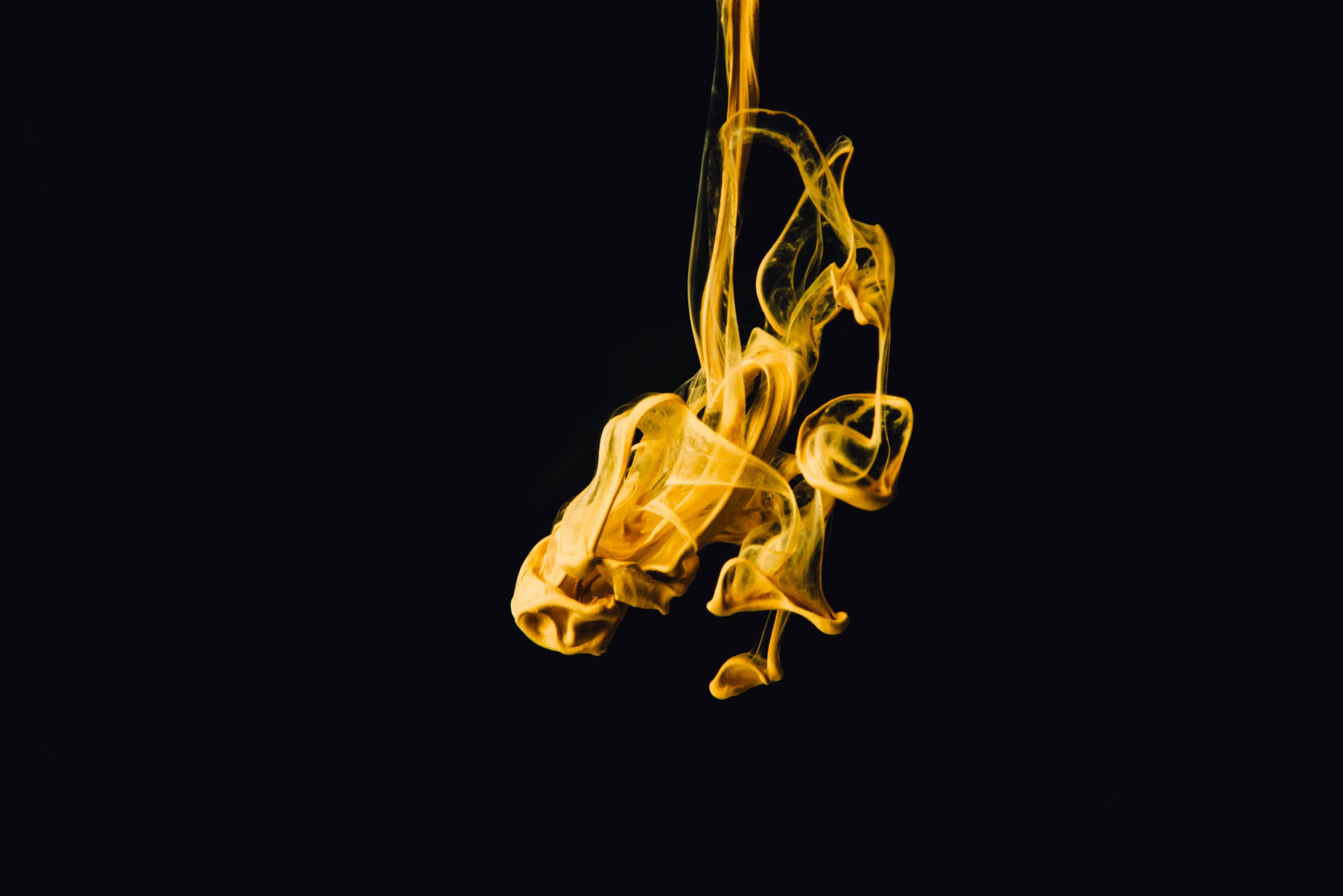 抽象 桌布 壁紙 — 金色煙霧在深黑色背景上優雅地旋轉，形成迷人的抽象舞蹈。