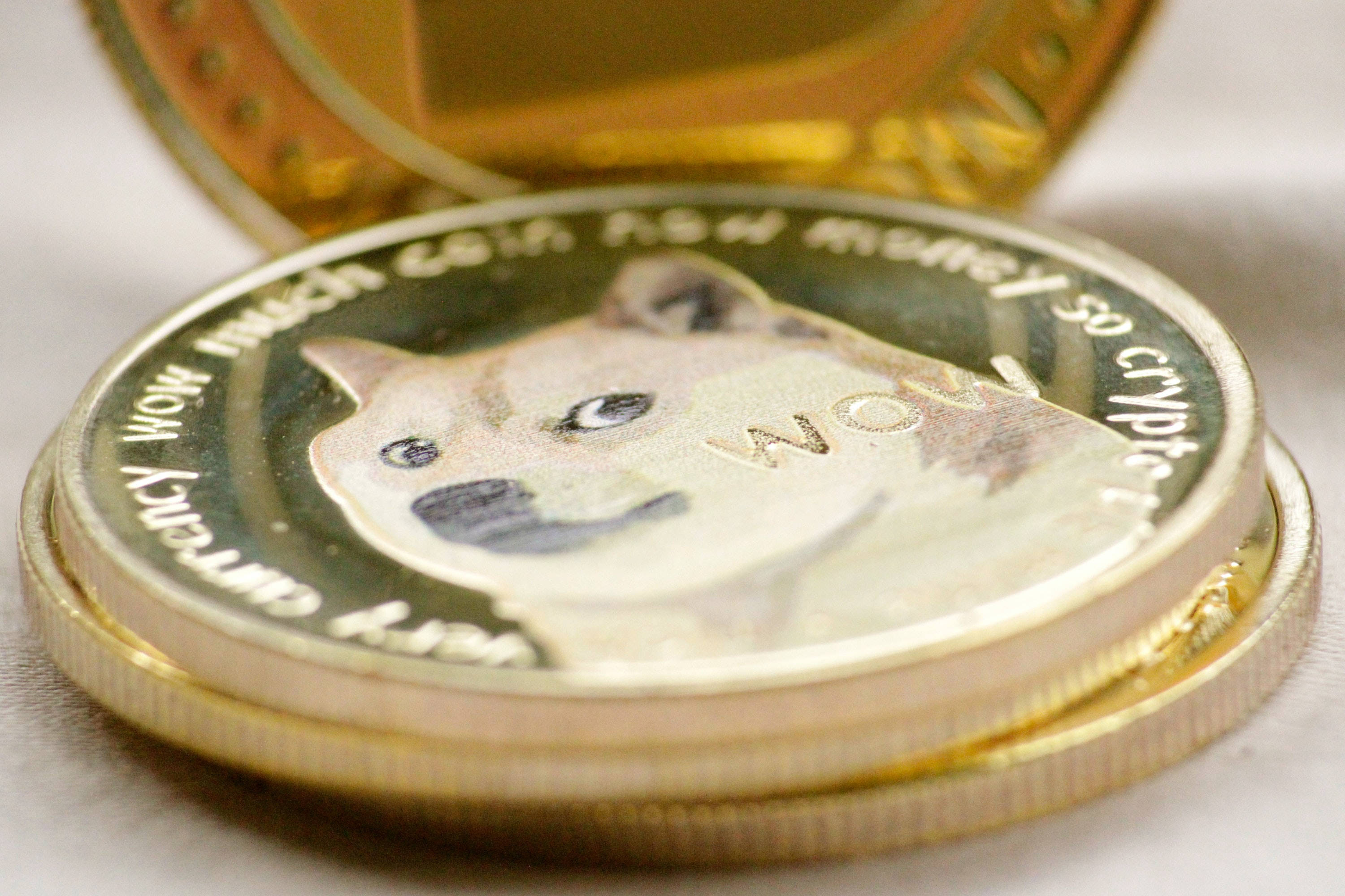 Dogecoin 桌布 壁紙 — 金色狗狗幣特寫，上面有柴犬狗臉、'WOW'文字和加密貨幣銘文。