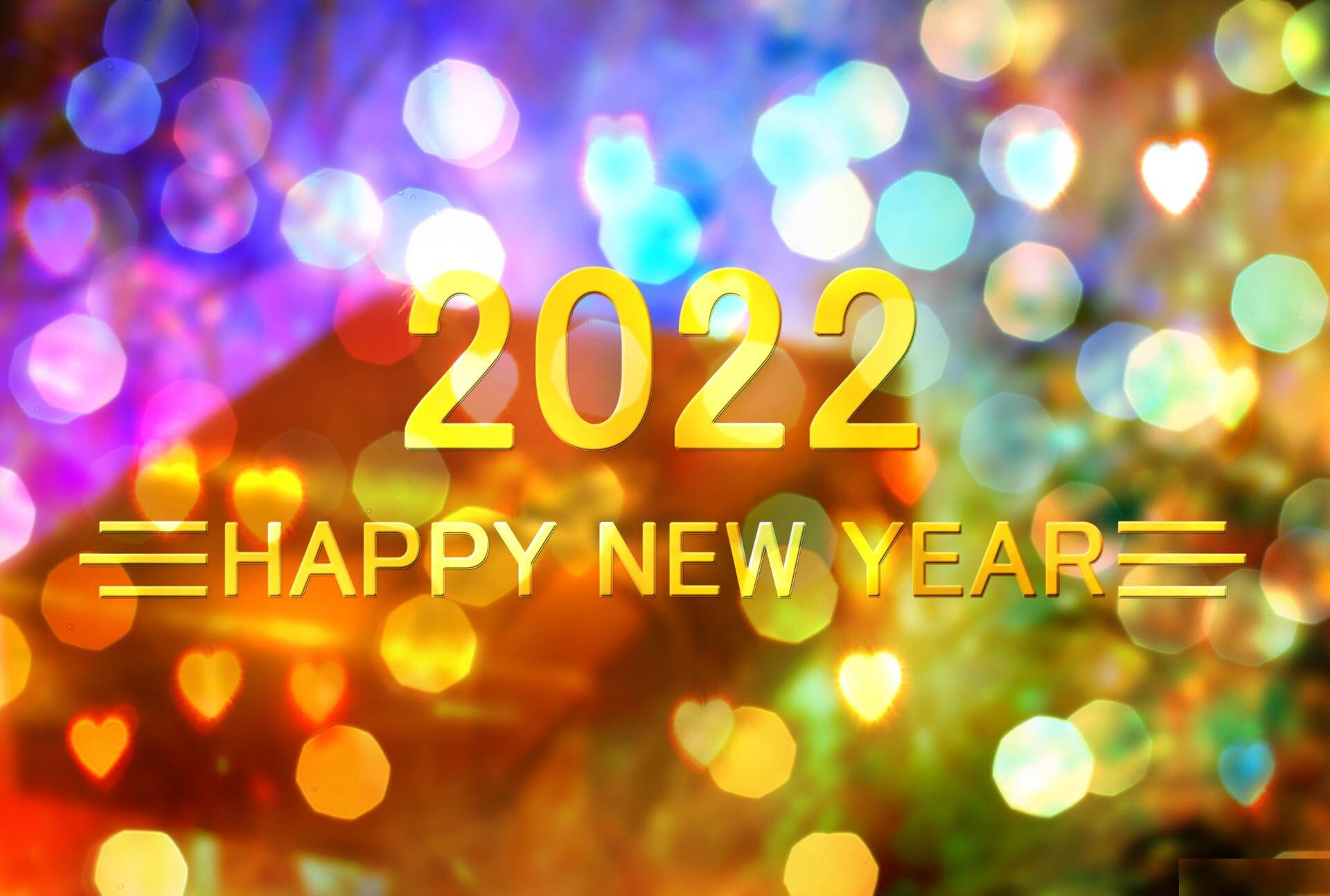 New 桌布 壁紙 — 金色的「2022 HAPPY NEW YEAR」文字在色彩繽紛的心形燈光的節日散景背景上發光。