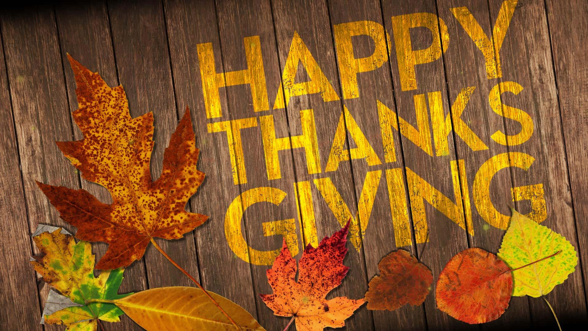 Happy Thanksgiving 桌布 壁紙 — 金色的「HAPPY THANKSGIVING」文字畫在風化的木頭上，周圍環繞著鮮豔的秋葉。