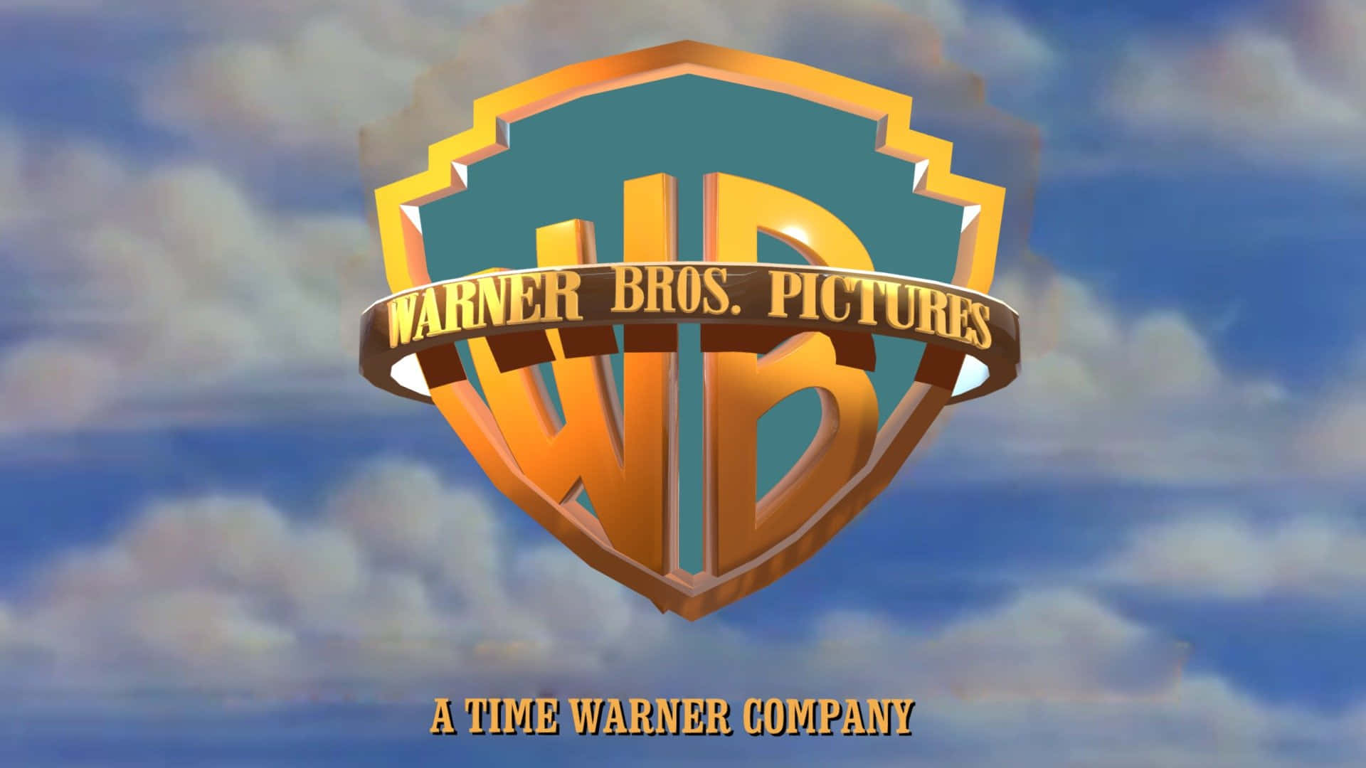 Warner Bros 桌布 壁紙 — 金色的 Warner Bros Pictures 盾牌標誌漂浮在晴朗的藍天和蓬鬆的白雲前面。