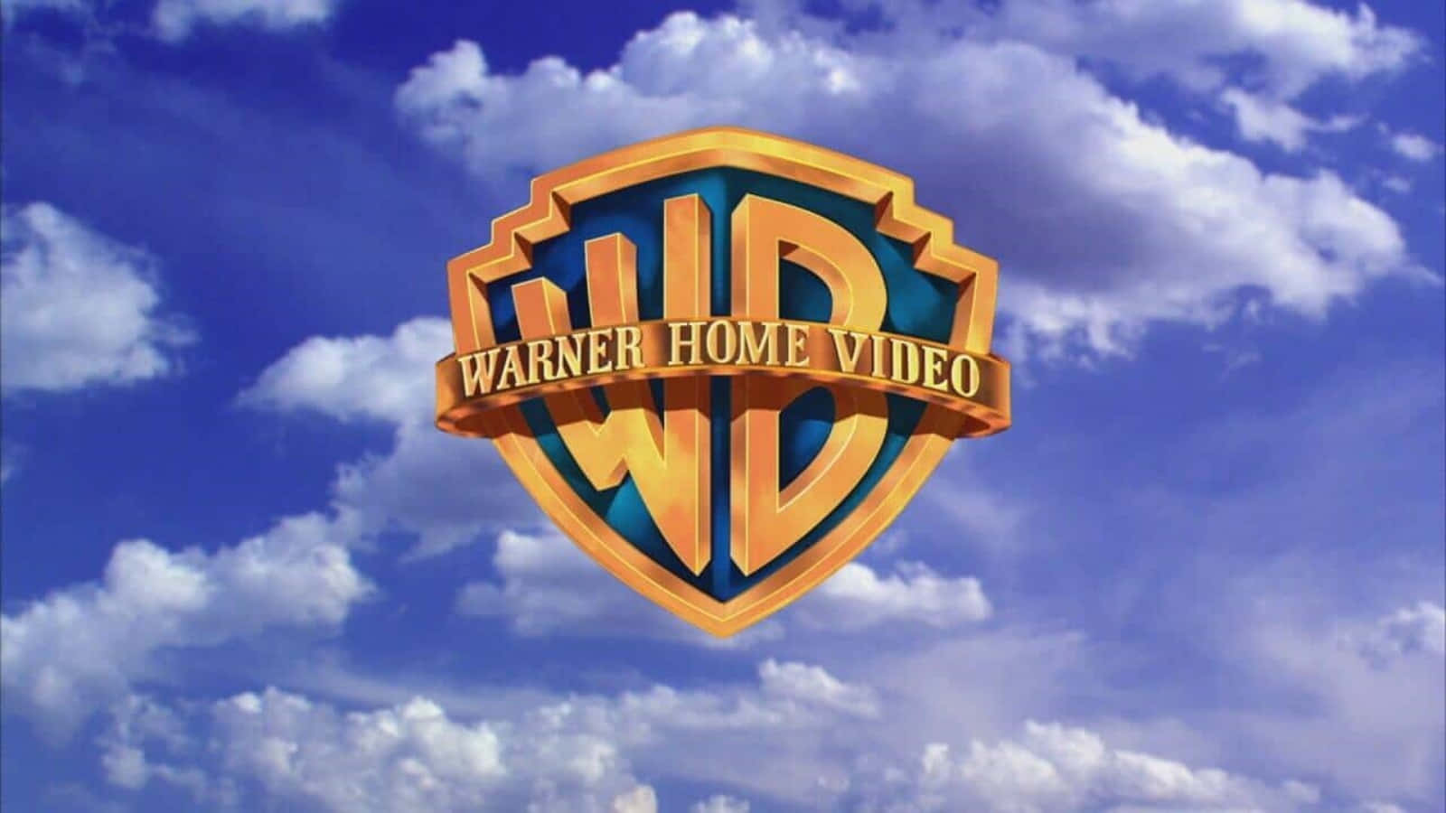 Warner Bros 桌布 壁紙 — 金色的 Warner Home Video 標誌漂浮在充滿蓬鬆白雲的鮮豔藍天之上。