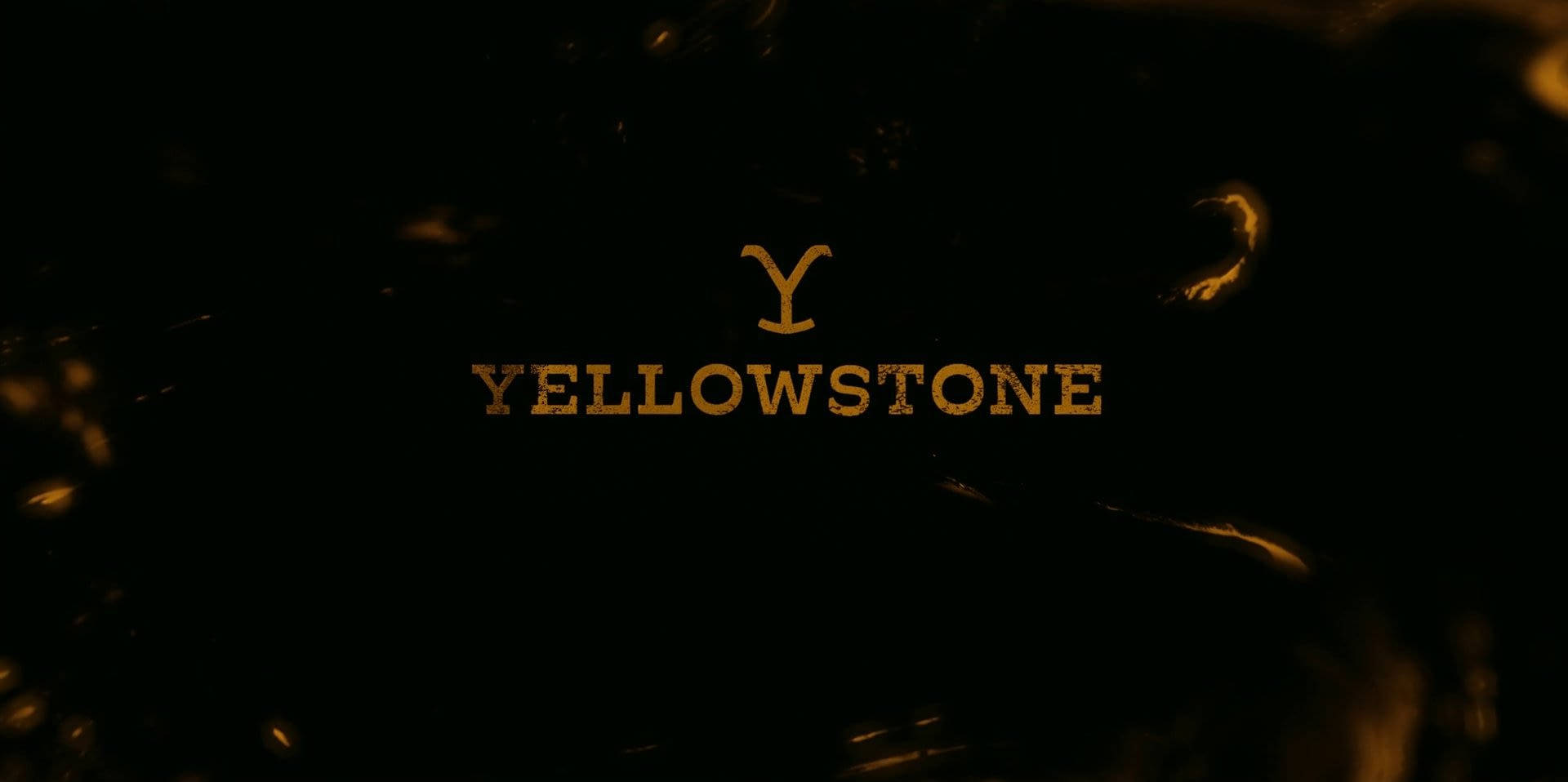 金色 Yellowstone 標誌在黑暗背景上帶有發光火花 — 黄石电视剧 壁紙