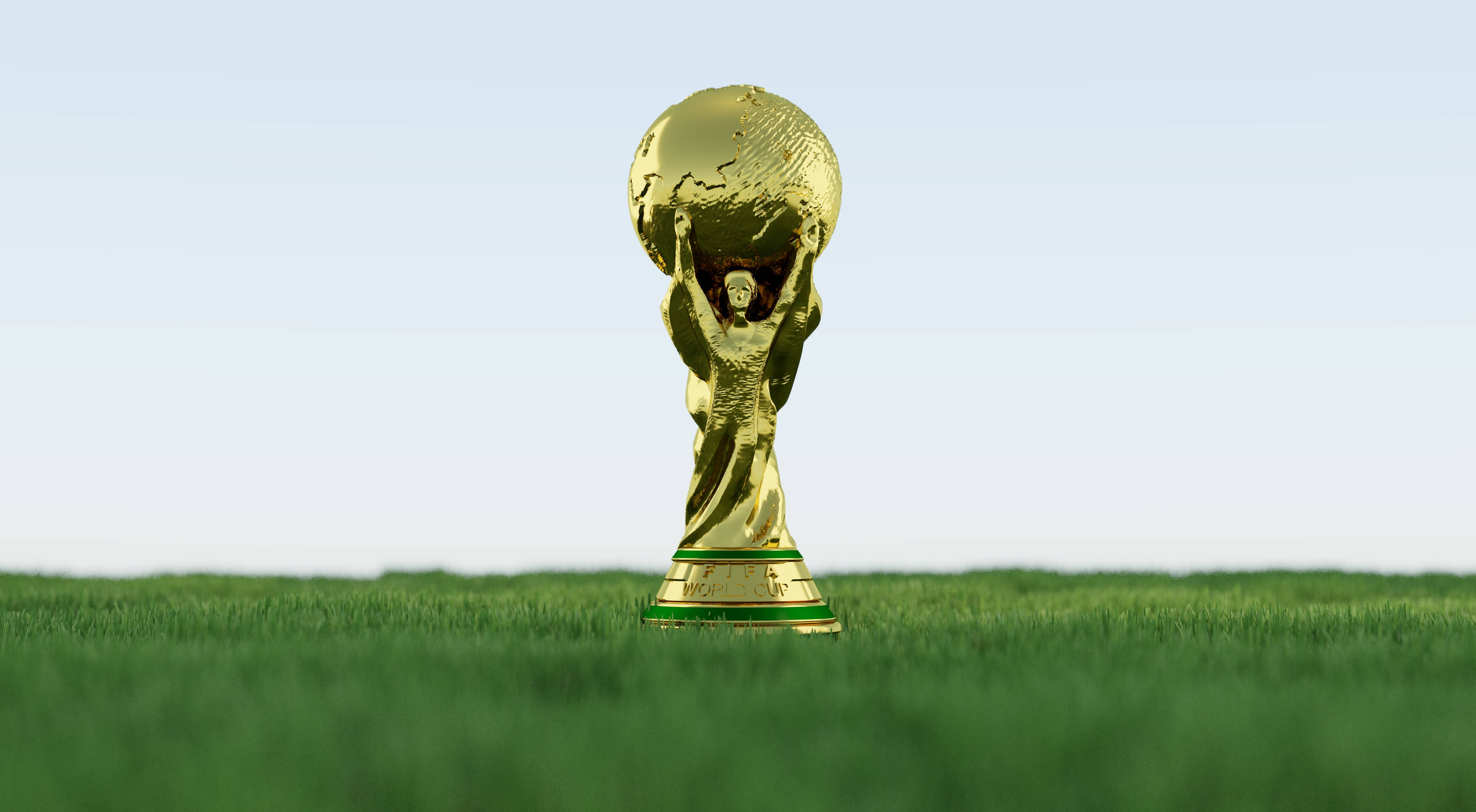 World 桌布 壁紙 — 金色的FIFA世界盃獎盃在晴朗的天空下自豪地矗立在充滿活力的綠色草地上。
