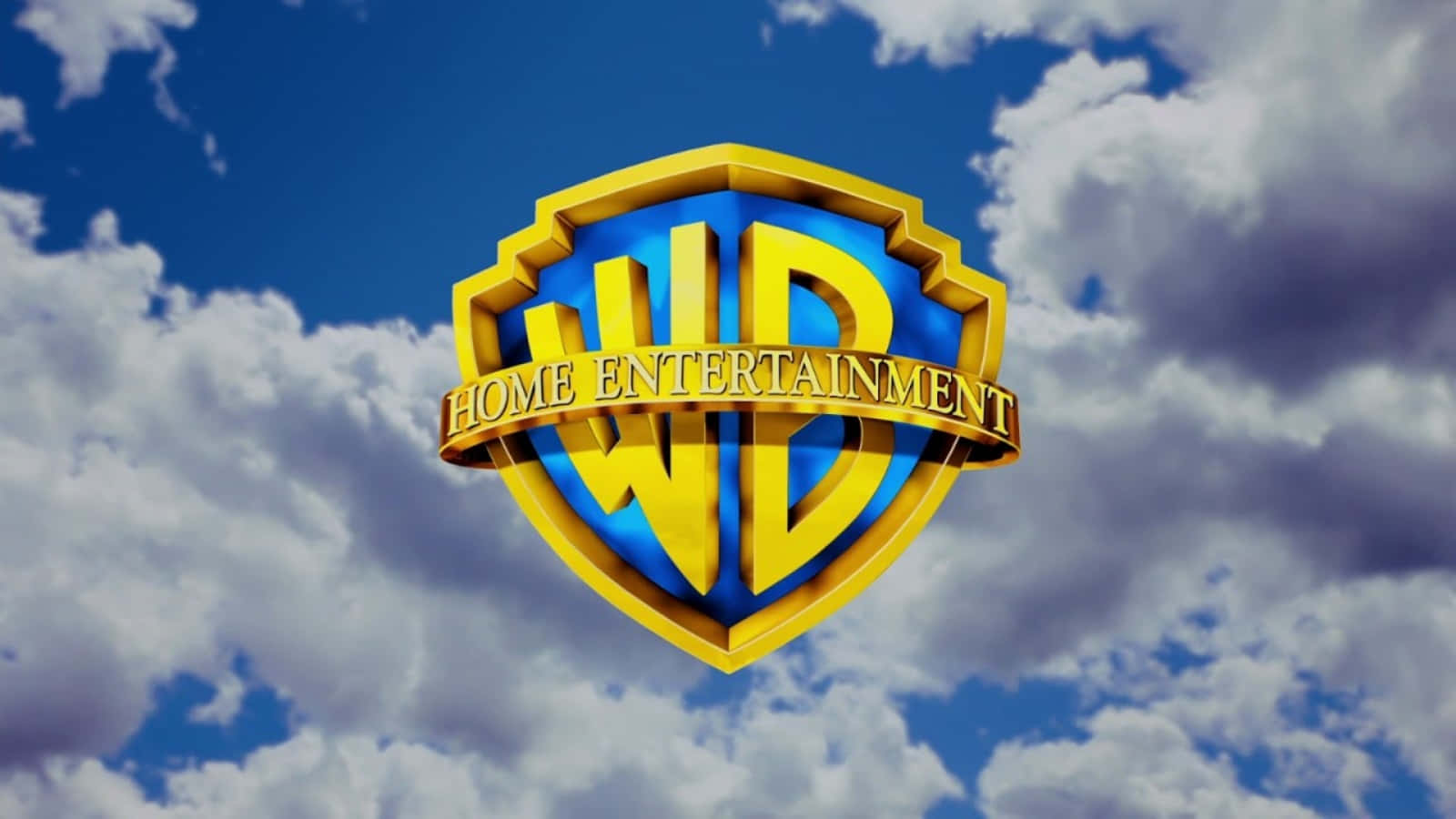 Warner Bros 桌布 壁紙 — 金色的Warner Bros Home Entertainment標誌漂浮在充滿蓬鬆白雲的鮮豔藍天上。
