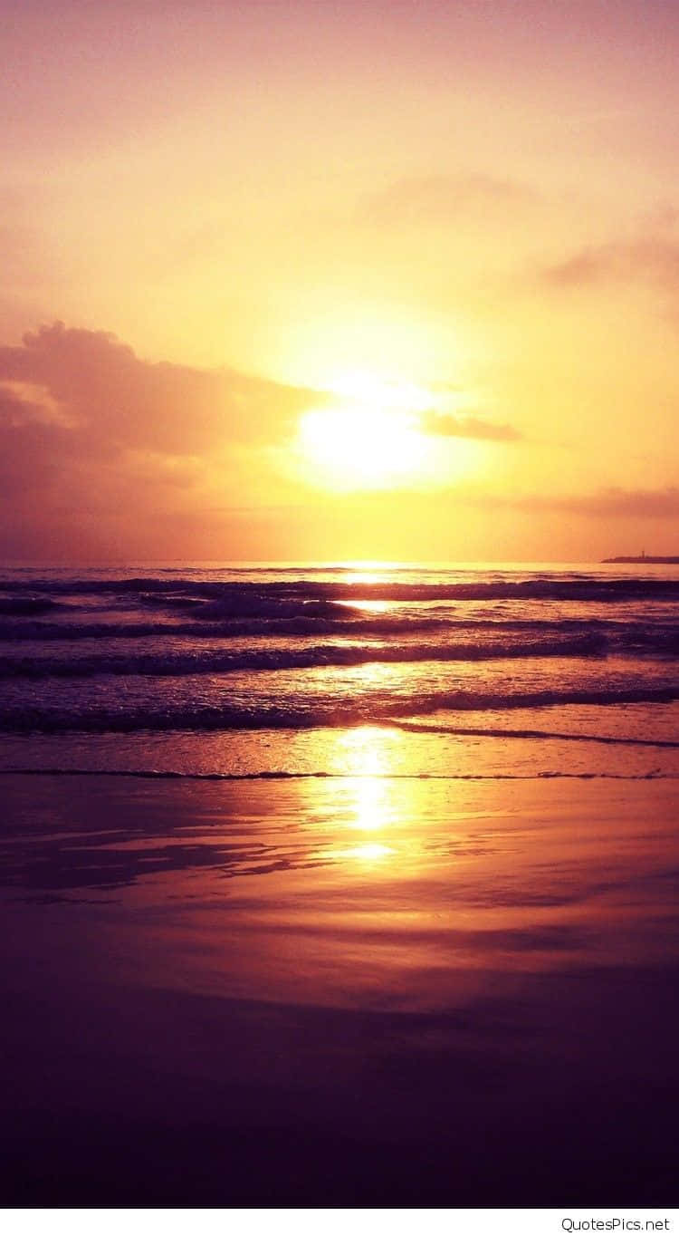 Sunset Beach iPhone 桌布 壁紙 — 金色的夕陽照耀著海浪沖刷沙灘，呈現柔和的紫色和橙色色調。
