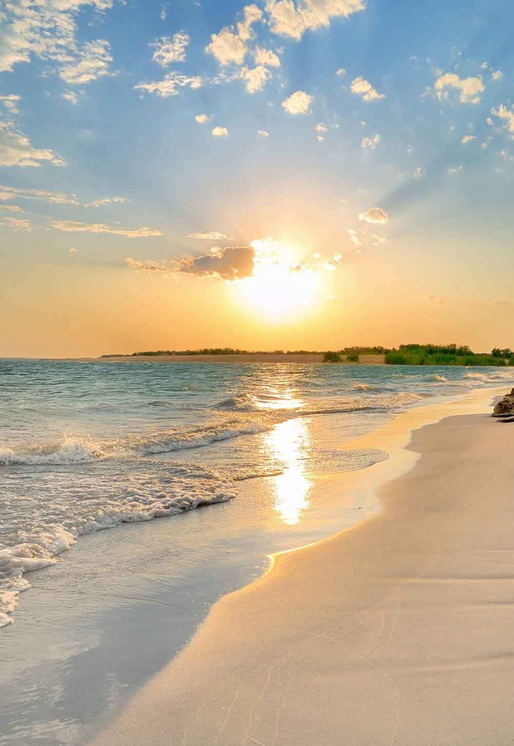 Summer Beach 桌布 壁紙 — 金色的夕陽穿過雲層，照耀在平靜的碧綠海面上，海浪沖刷著純淨的白色沙灘。