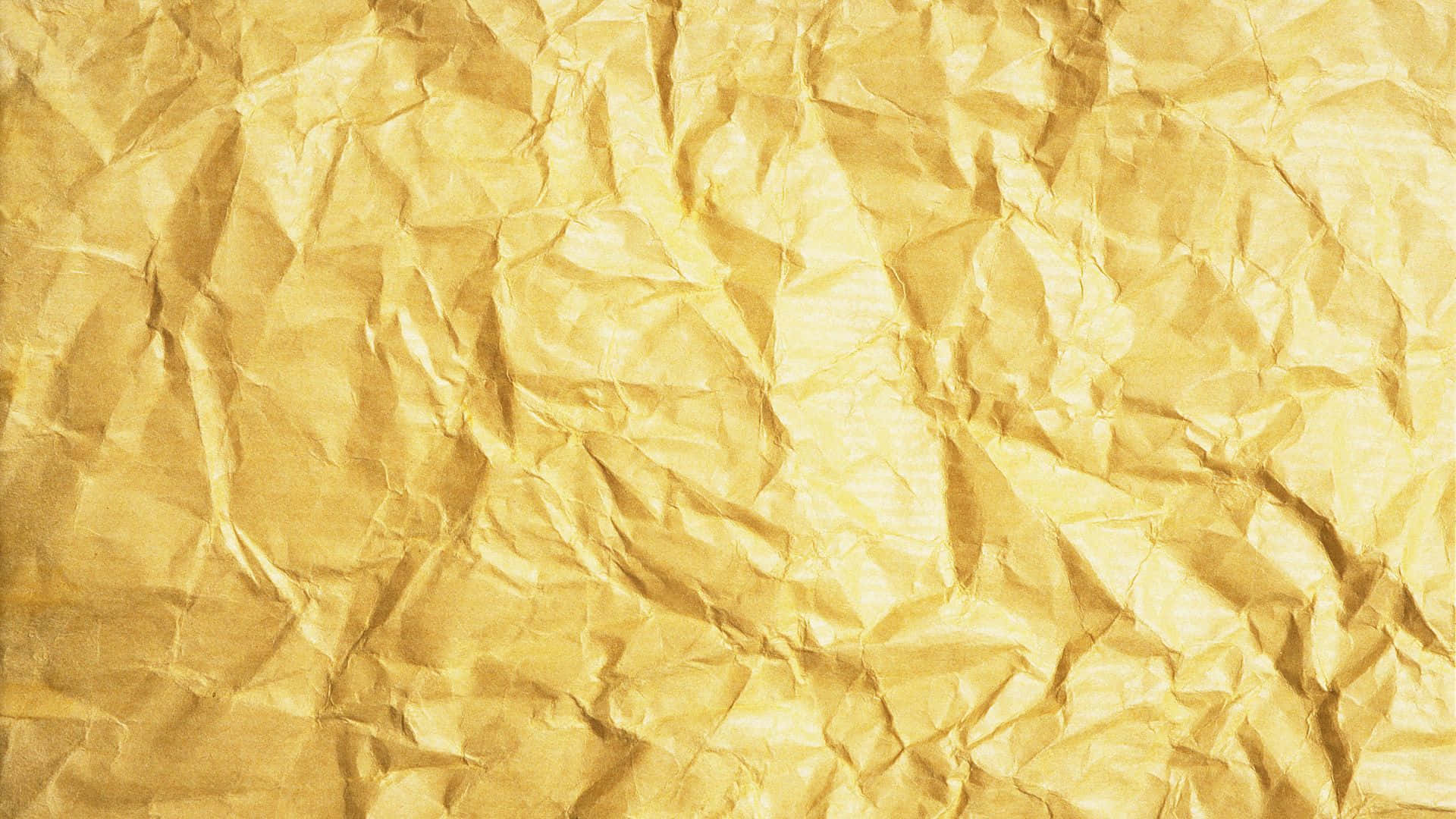 Textured 桌布 壁紙 — 金色皺紙的特寫，帶有紋理摺痕和溫暖高光。