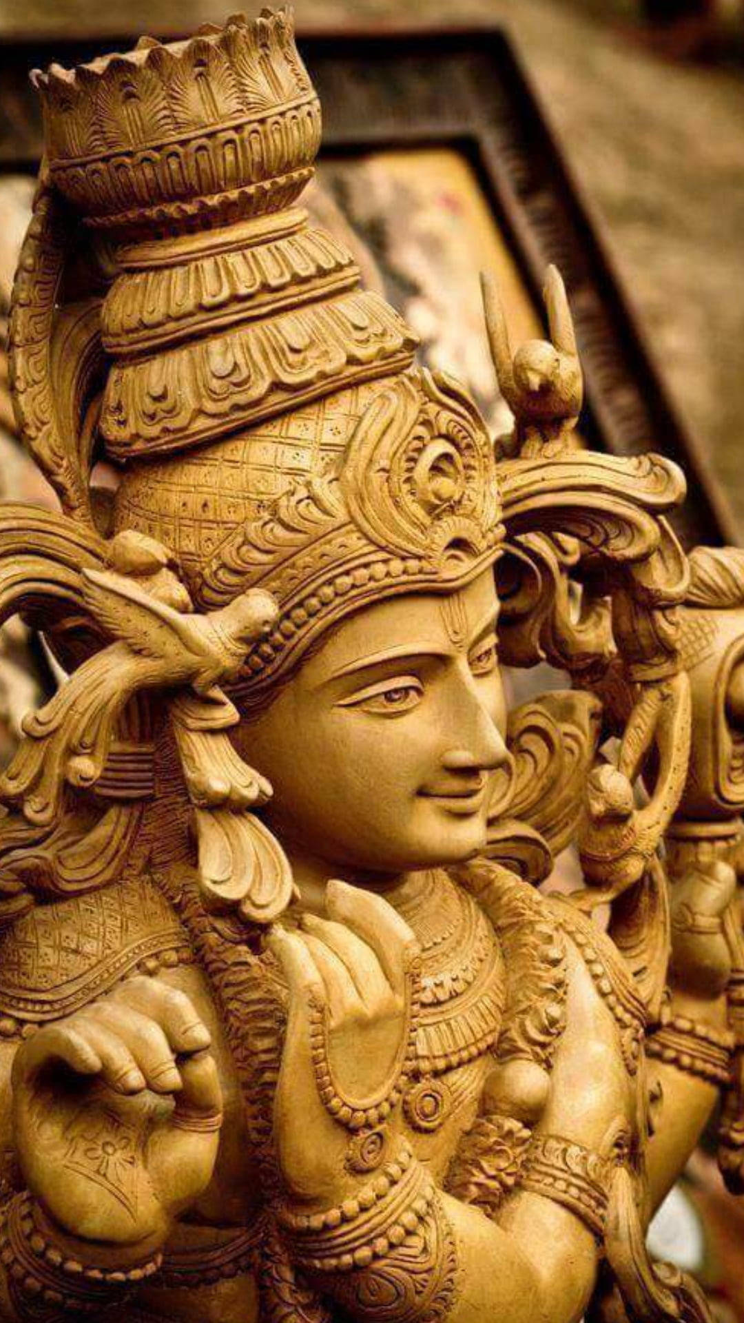 hindu iPhone 桌布 壁紙 — 金色神像特寫，雕刻精細，頭飾華麗，表情寧靜。