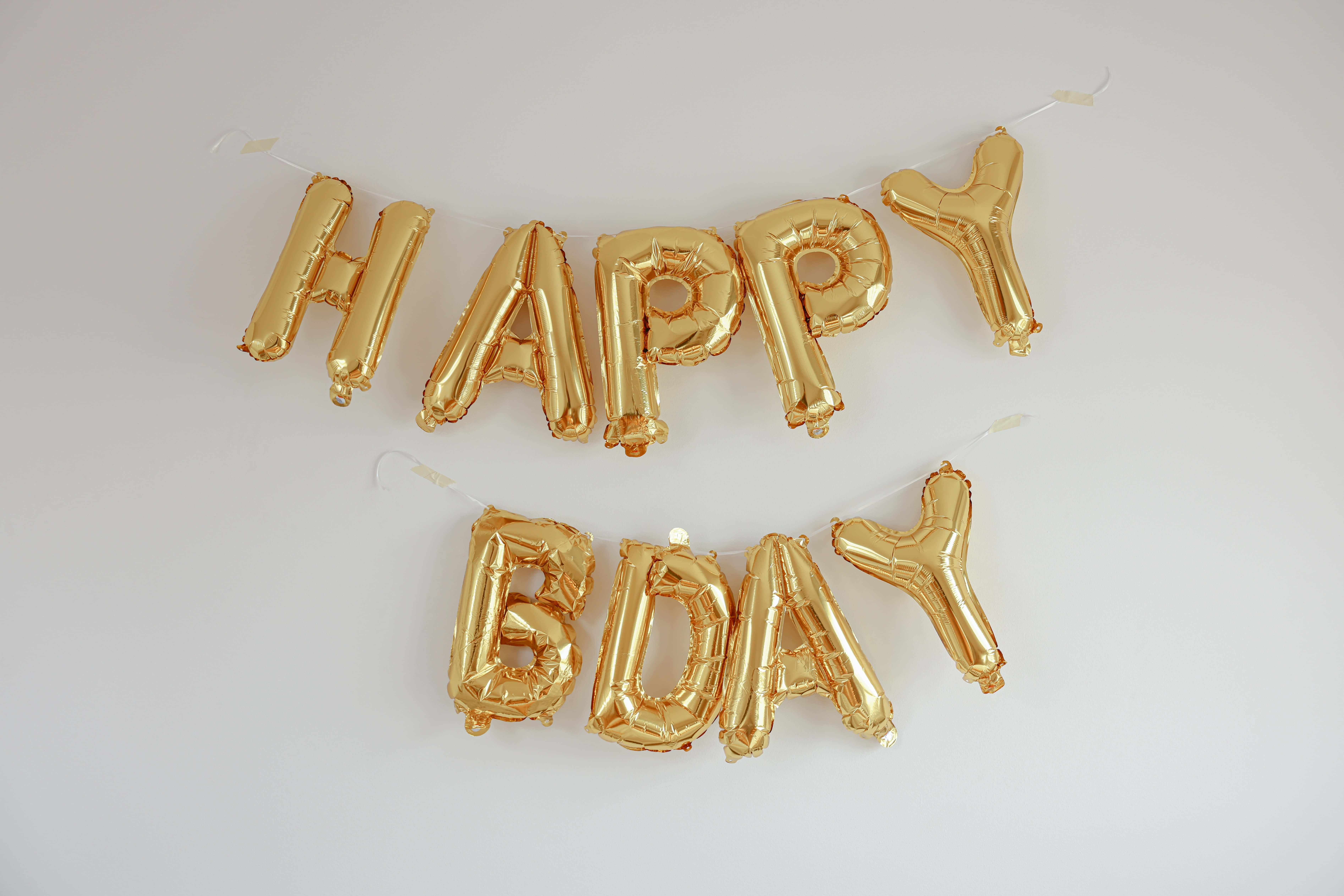 生日快樂 桌布 壁紙 — 金色箔氣球在純白背景上拼出 HAPPY BDAY。