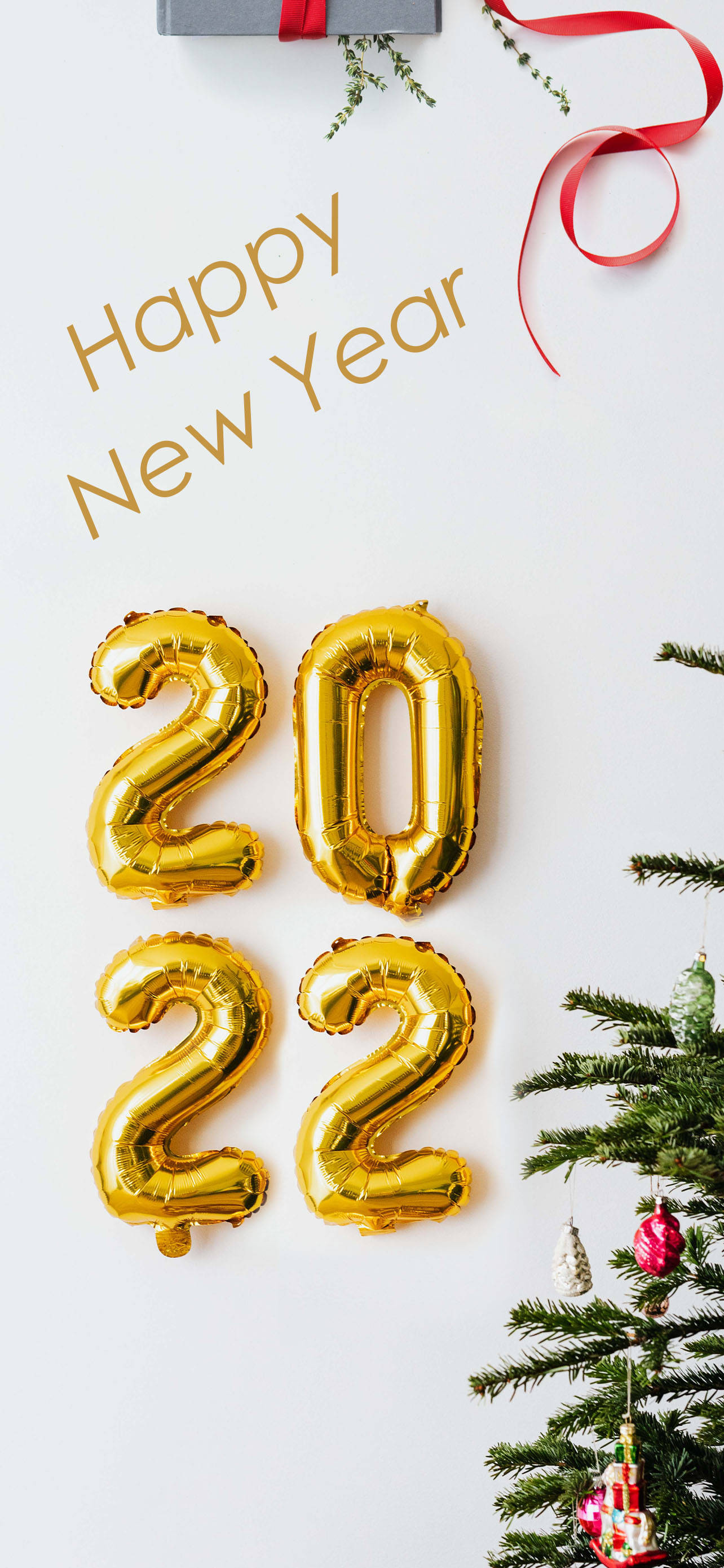 Happy New Year 2022 桌布 壁紙 — 金色箔氣球形狀為2022，漂浮在裝飾好的聖誕樹和「Happy New Year」文字旁邊，背景為白色。