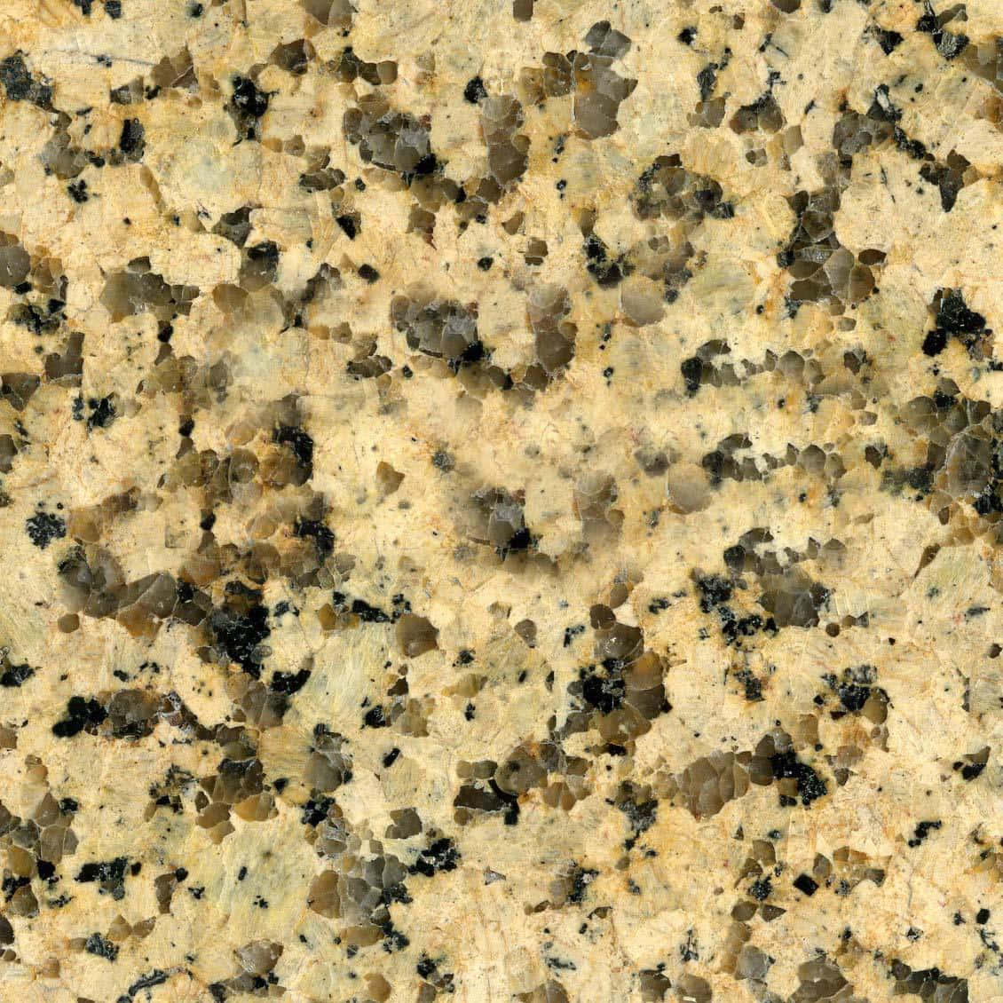 Granite 桌布 壁紙 — 金色米色花崗岩的特寫，散佈著黑色和灰色的礦物斑點及結晶質紋理。