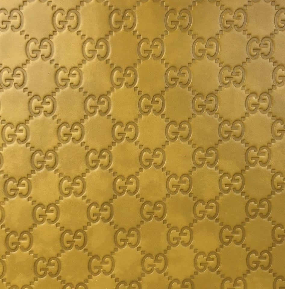 Gucci 桌布 壁紙 — 金色紋理壁紙，帶有重複交錯的GG字母組合圖案，呈菱形網格排列。