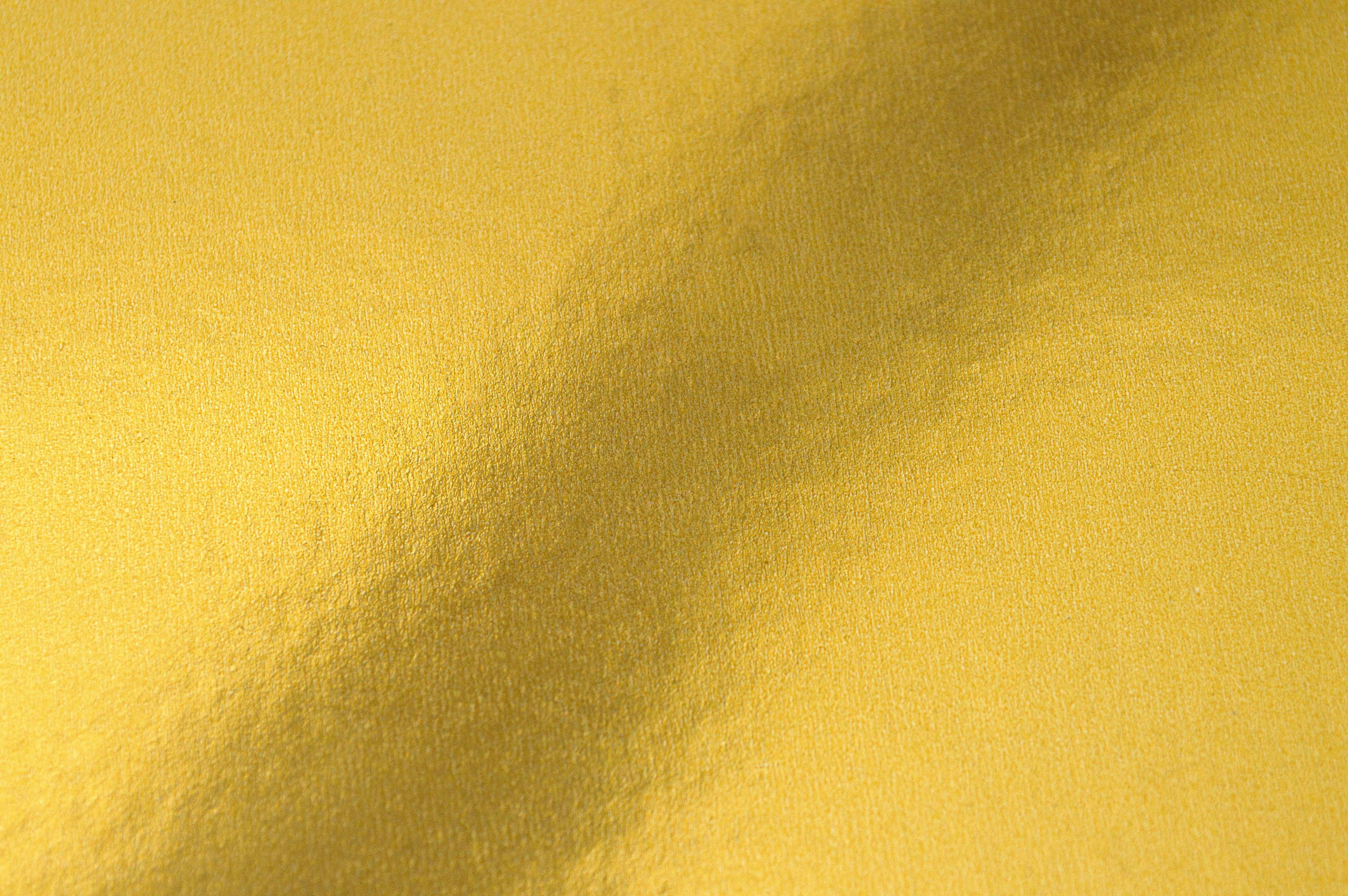 Gold Abstract 桌布 壁紙 — 金色紋理布料的特寫，帶有柔軟的摺痕和微妙的燈光變化。