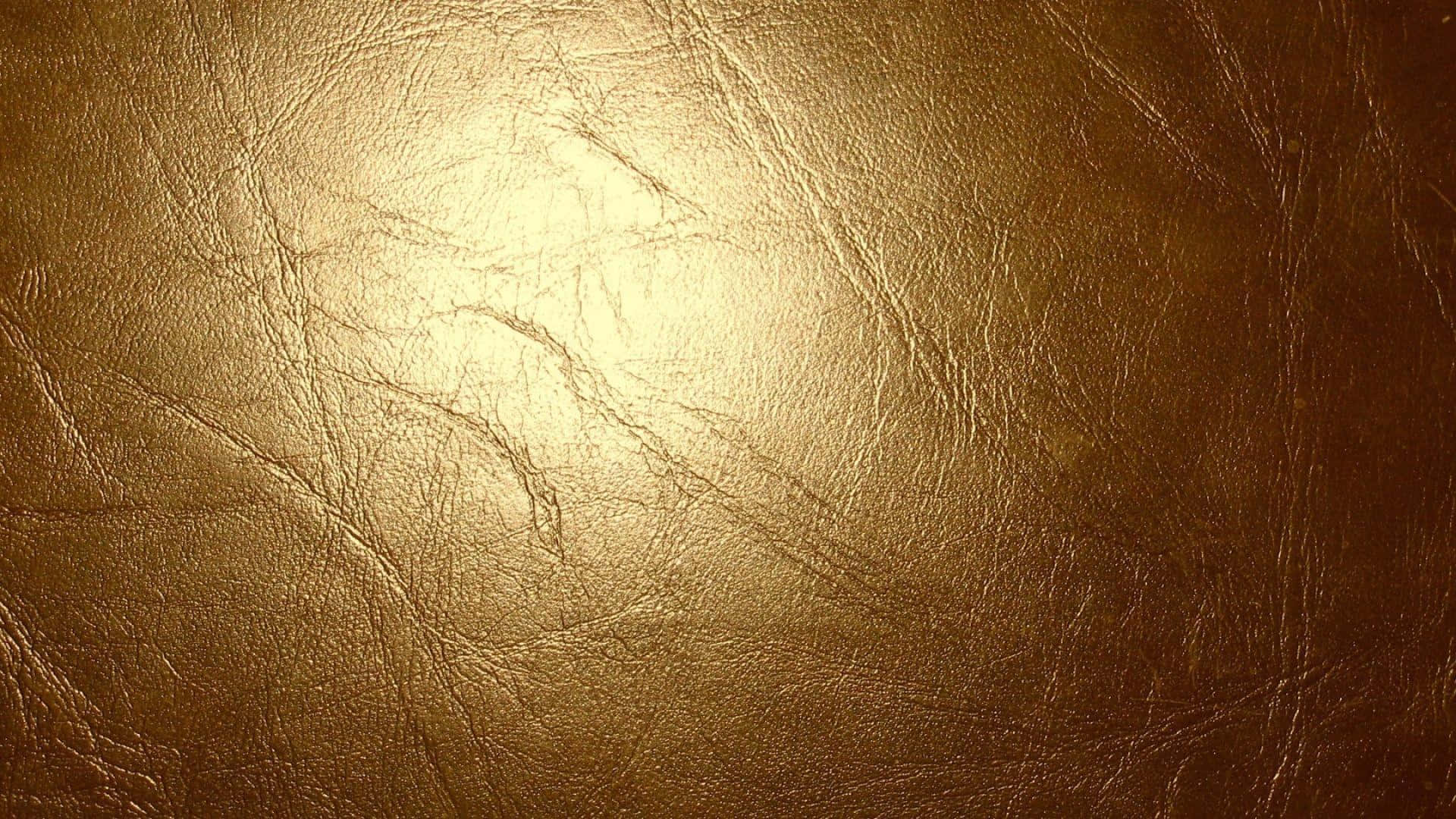 Leather 桌布 壁紙 — 金色紋理皮革表面，在柔和光線下呈現自然皺褶和溫暖高光。