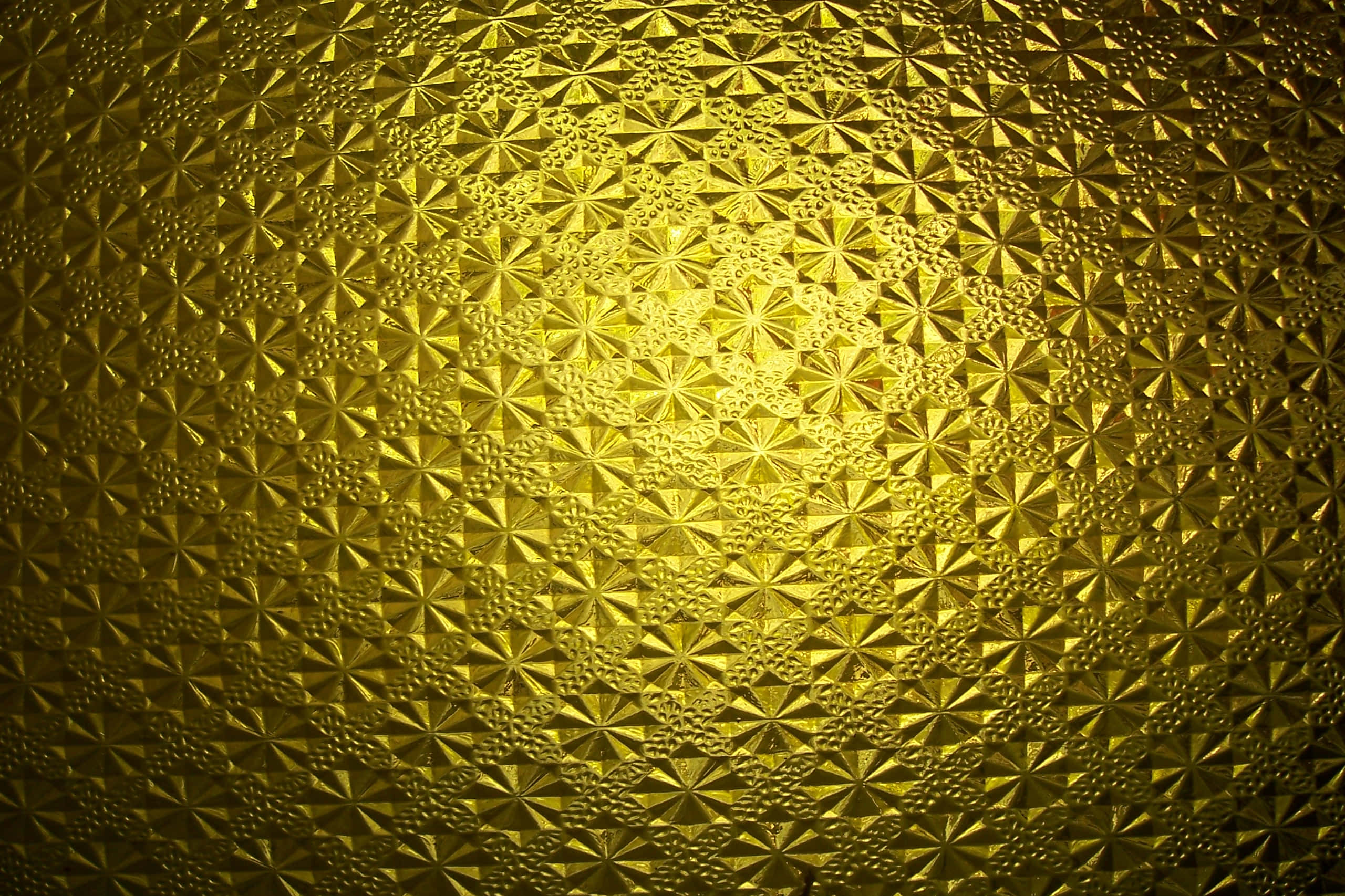 設計 桌布 壁紙 — 金色紋理表面，帶有重複的星形圖案，被溫暖的光線照亮。