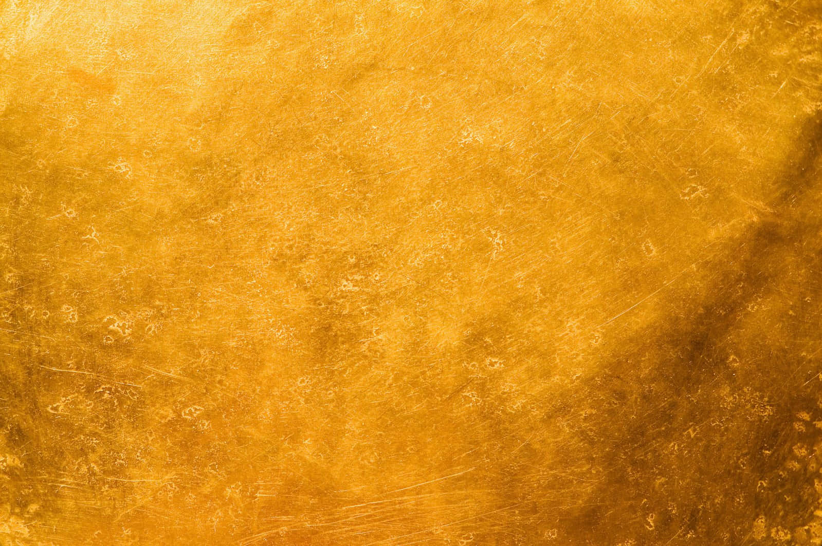 Gold Texture 桌布 壁紙 — 金色紋理表面的特寫，帶有刮痕和斑駁高光。