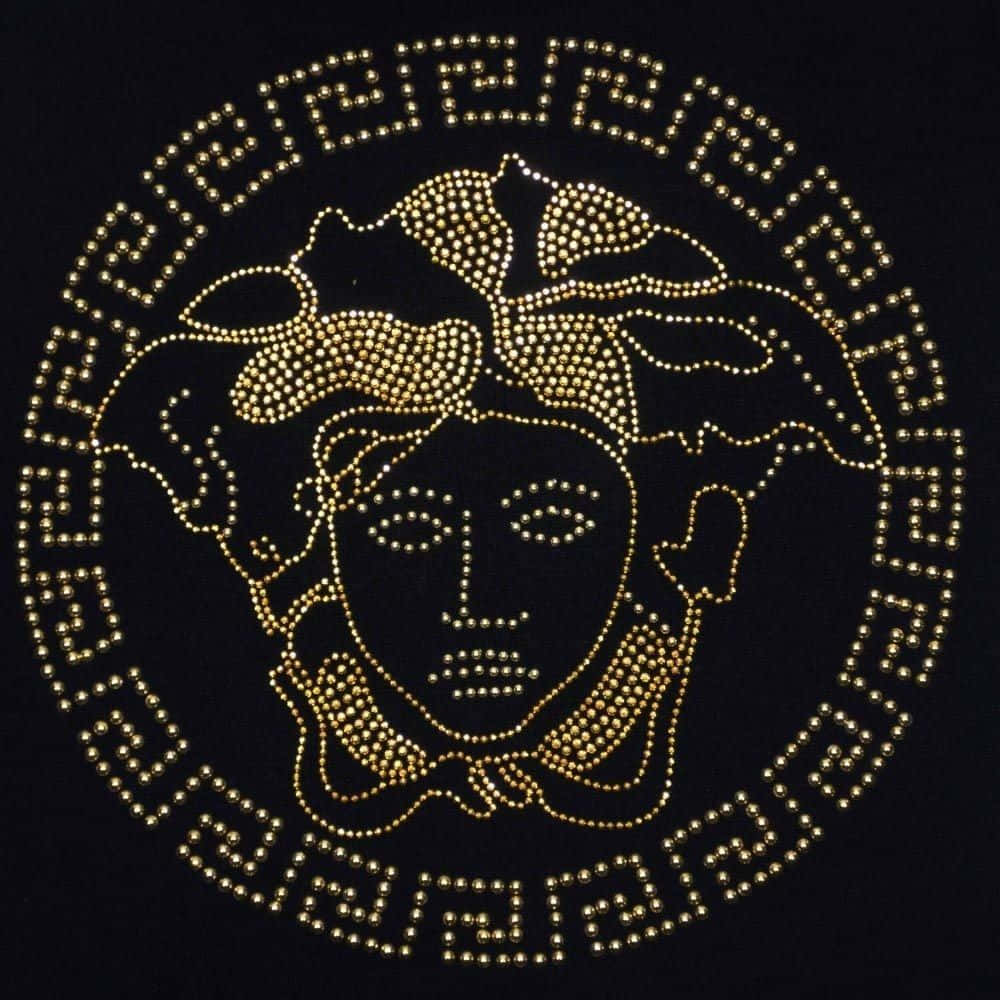 versace 桌布 壁紙 — 金色美杜莎頭像標誌，由閃亮水鑽製成，置於黑色背景上，帶有希臘鑰匙邊框。