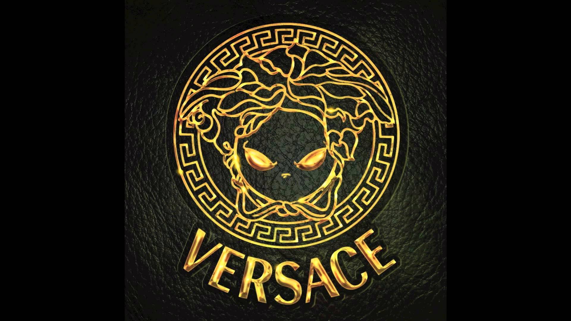 Versace Logo 桌布 壁紙 — 金色美杜莎頭標誌，帶有 'VERSACE' 文字，壓印在紋理黑色皮革背景上。