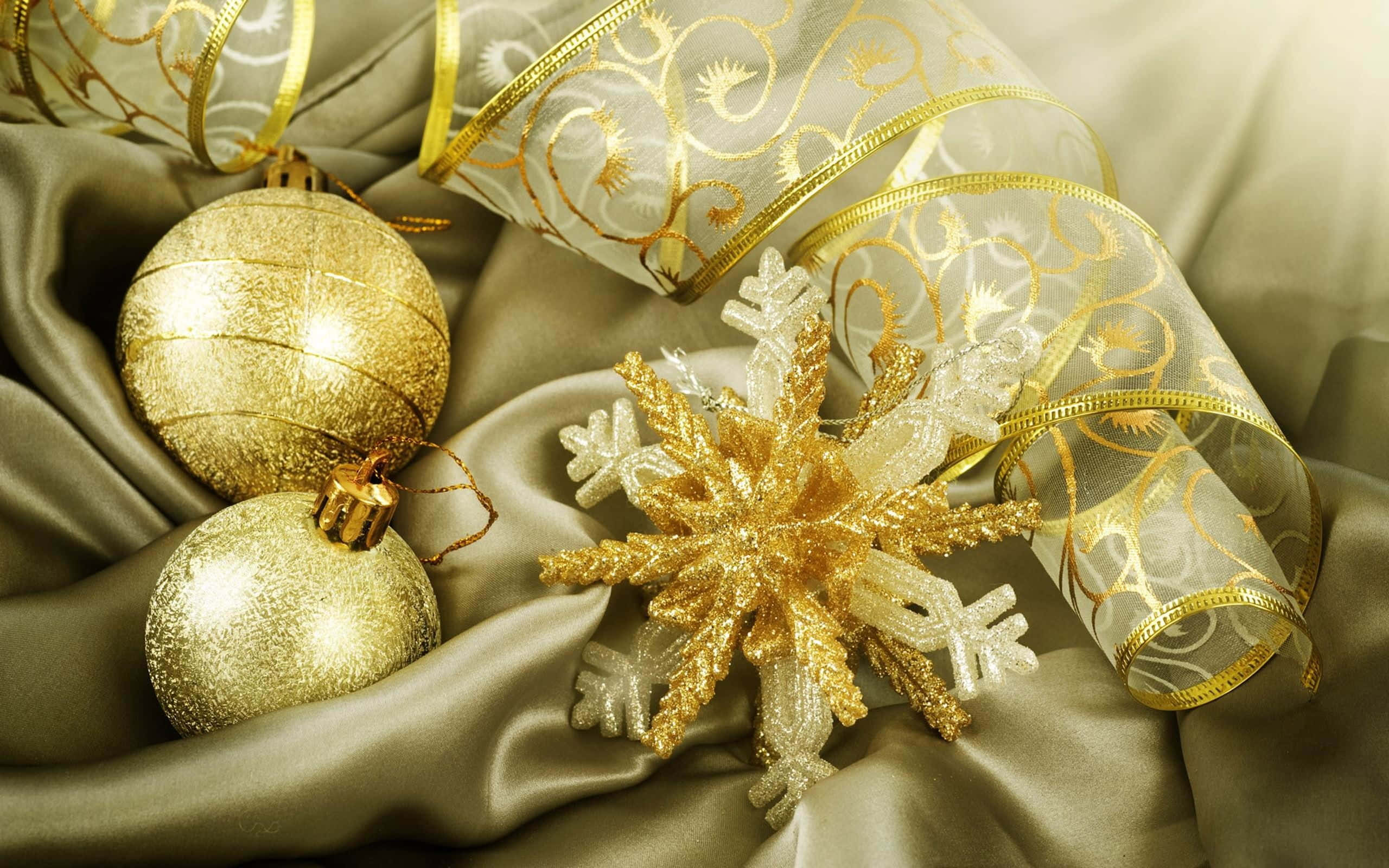 Gold Christmas 桌布 壁紙 — 金色聖誕裝飾和雪花裝飾優雅地放置在豪華緞面上，搭配溫暖的燈光。