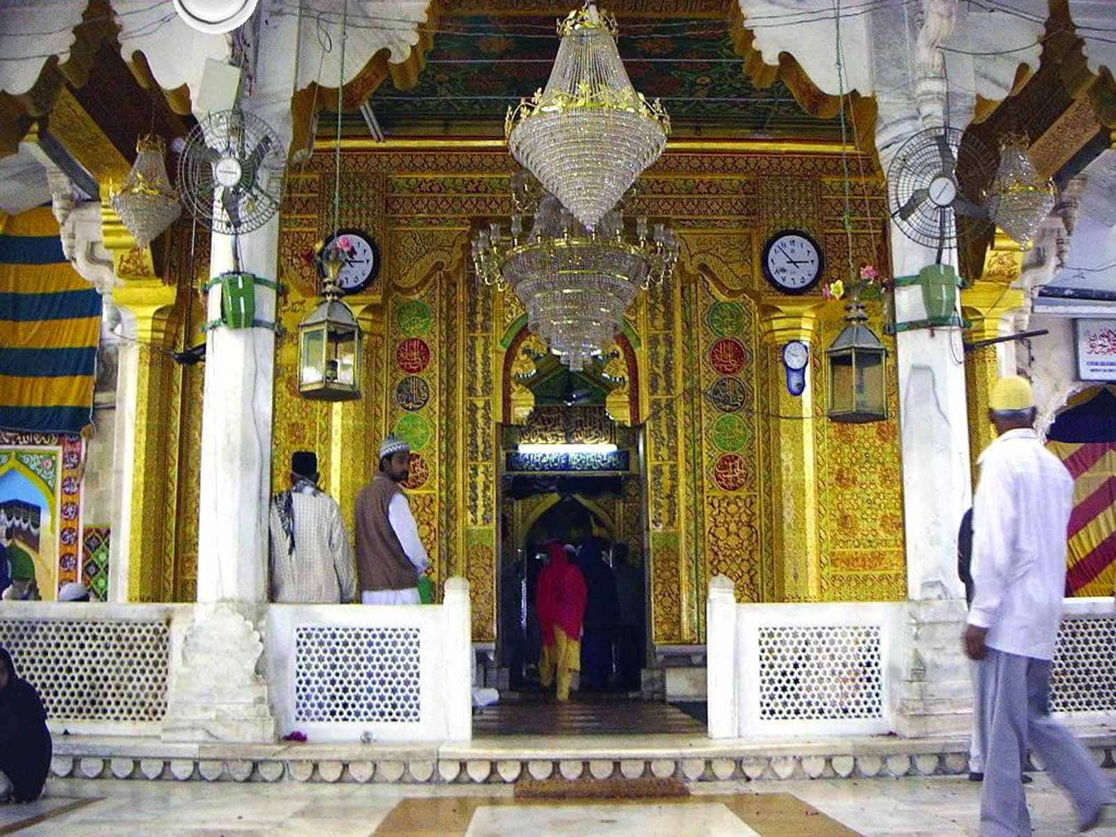 muslim 桌布 壁紙 — 金色華麗清真寺內部，懸掛水晶吊燈和穿著傳統服飾的禮拜者。