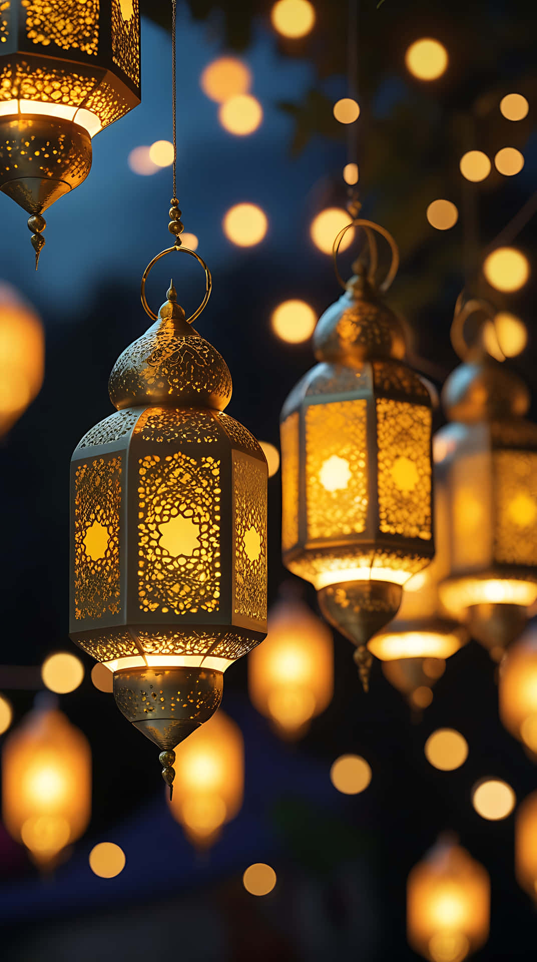 Golden Lantern Glow with Ramadan Kareem Greetings. smartphone wallpaper 壁紙 — 金色華麗燈籠懸掛著，在點綴著柔和散景燈光的深藍色夜空中溫暖地發光。