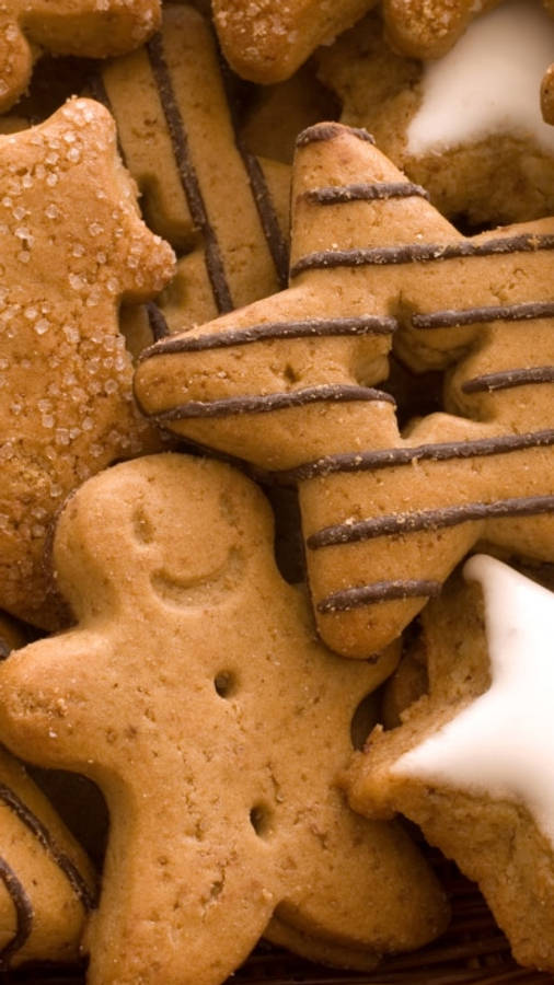Cookie 桌布 壁紙 — 金色薑餅餅乾的特寫，星星和小人形狀，淋上巧克力和糖晶體。